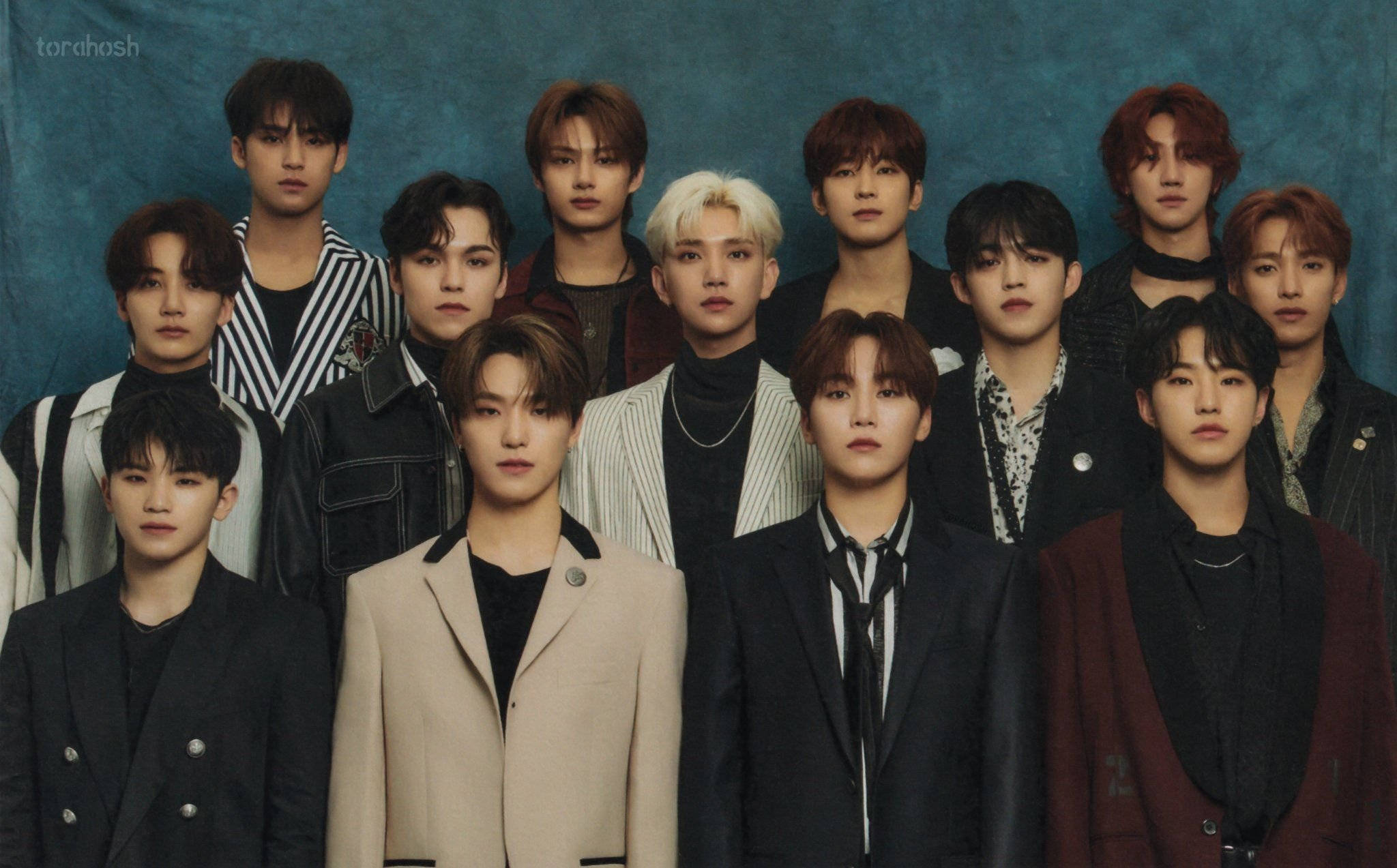 Wonwoo 與 SEVENTEEN 壁紙 — 一群穿著時尚西裝的年輕男性，在帶有紋理的青綠色背景前，以嚴肅的表情正式擺姿勢。