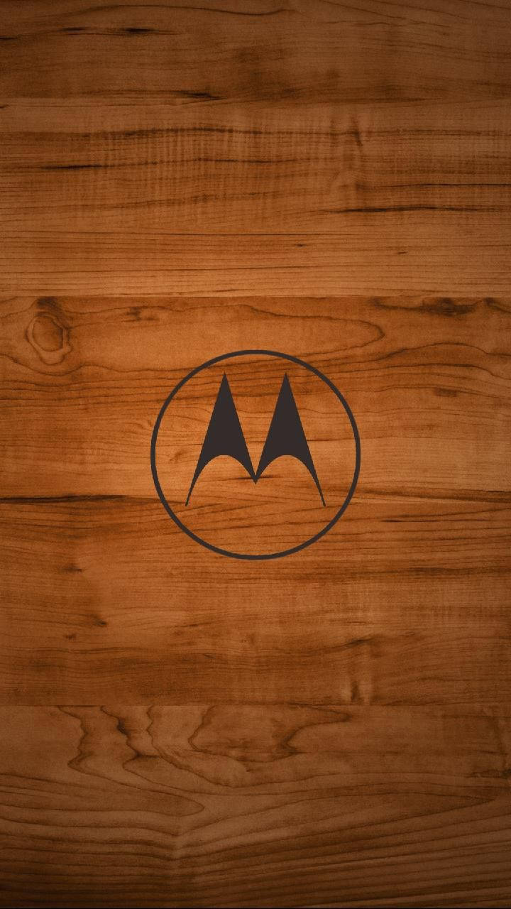Wooden Motorola Logo 壁紙 — Motorola 標誌在黑色圓圈中，置於溫暖棕色木紋壁紙中央。