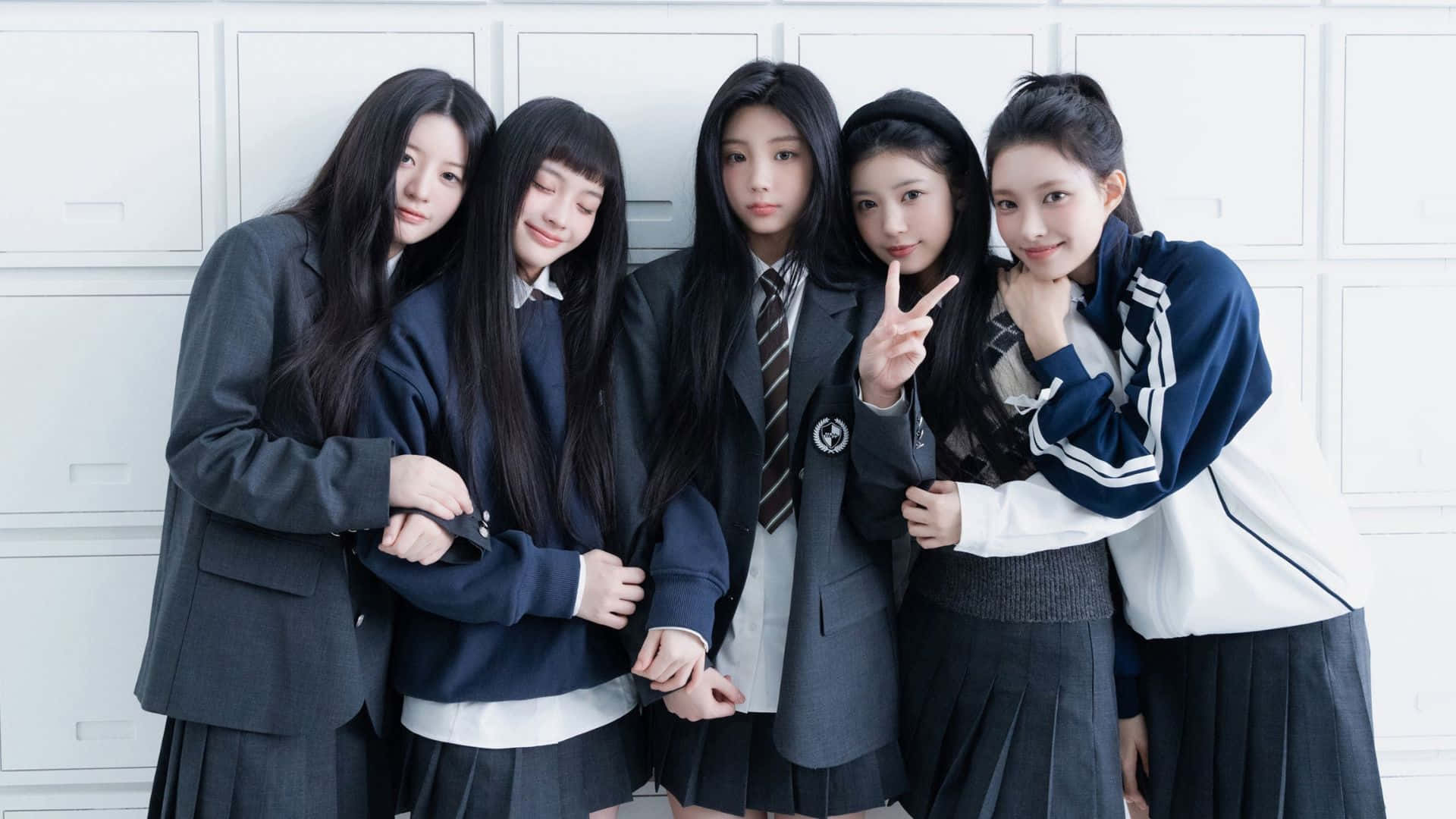  壁紙 — 五名身穿校服的年輕女性在白色儲物櫃牆前緊密地擺出俏皮的表情。