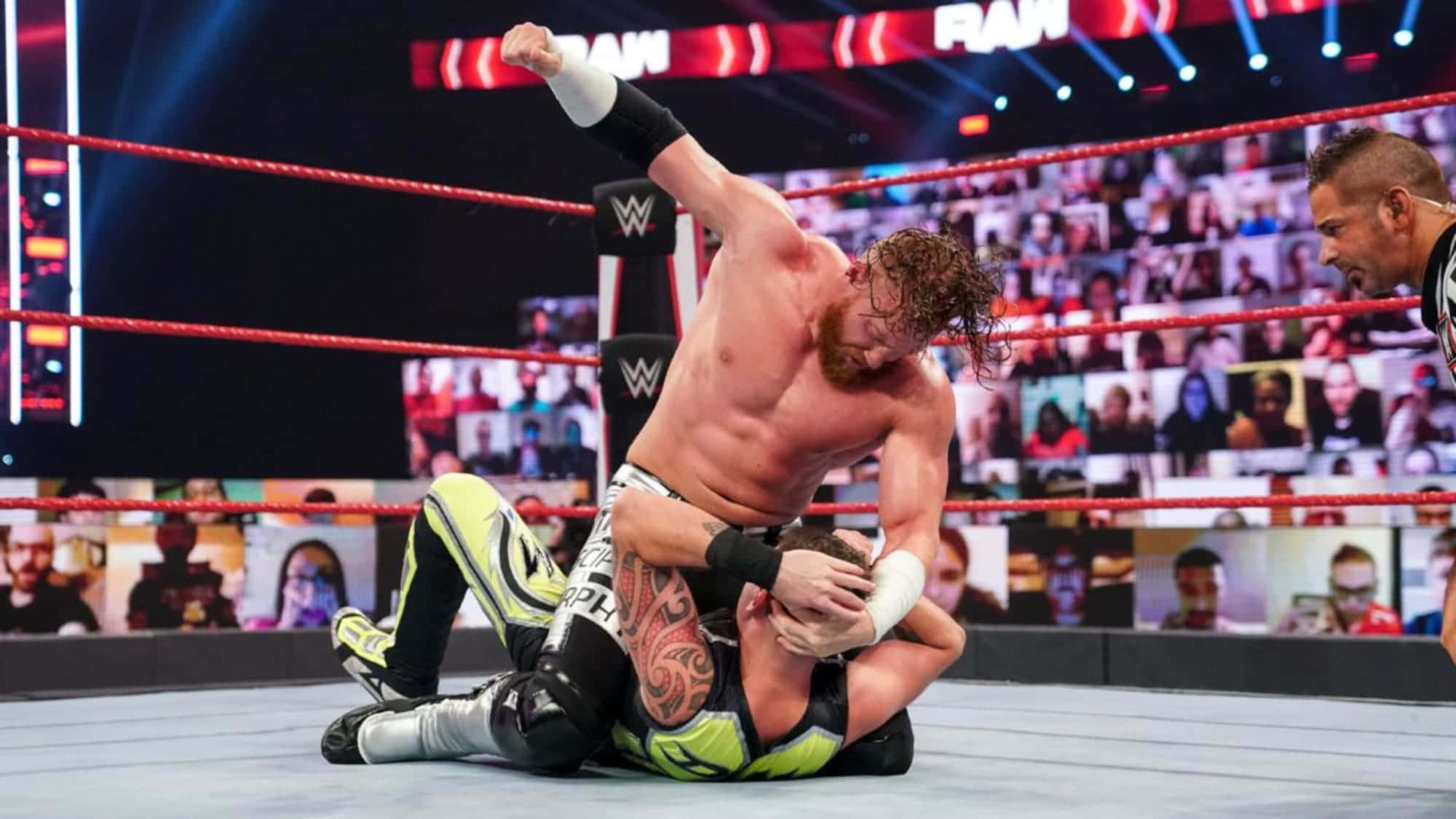 巴迪·墨菲對戰賽斯·羅林斯 WWE SmackDown 壁紙 — 一位紅色捲髮的摔角手在明亮的競技場燈光下，於摔角場中壓制對手。