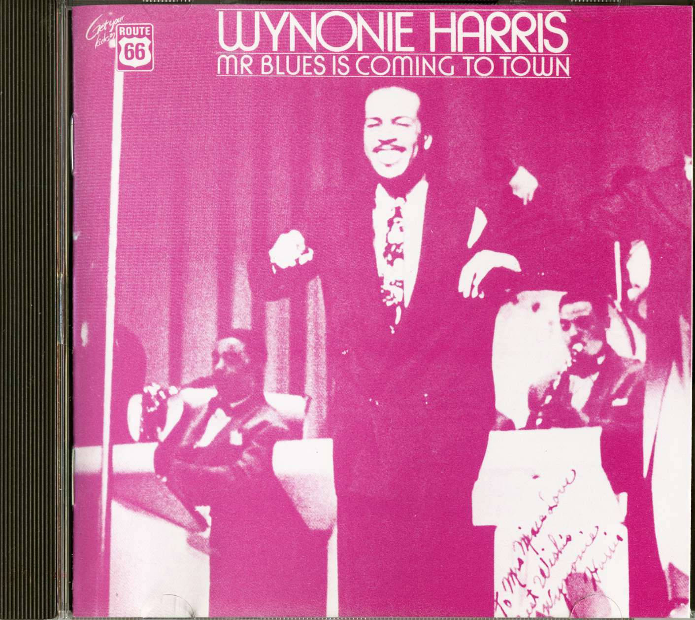 Wynonie Harris 在洋紅色調照片中與樂隊在舞台上表演藍調音樂。