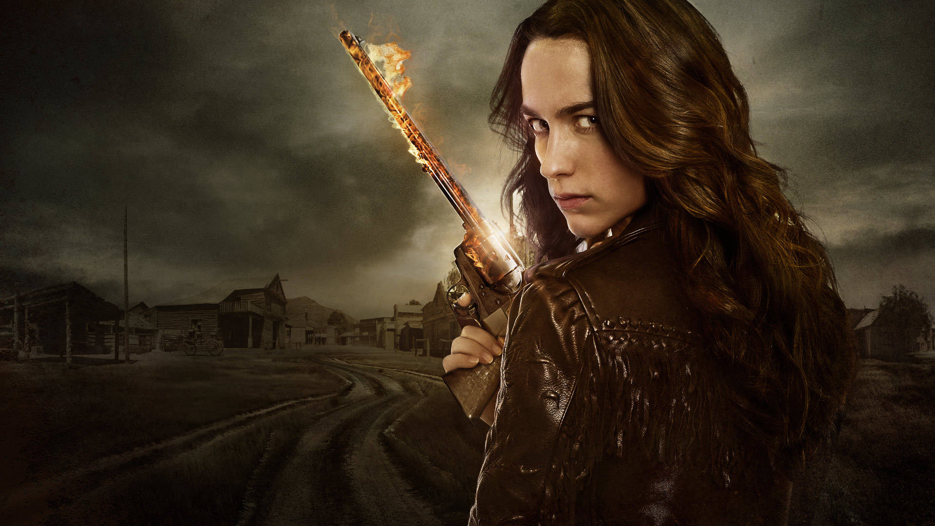 Wynonna Earp 燃燒的和平者 壁紙 — 一名穿著皮褸的女子在暴風雨天空下的荒涼西部小鎮中手持一把燃燒的散彈槍。