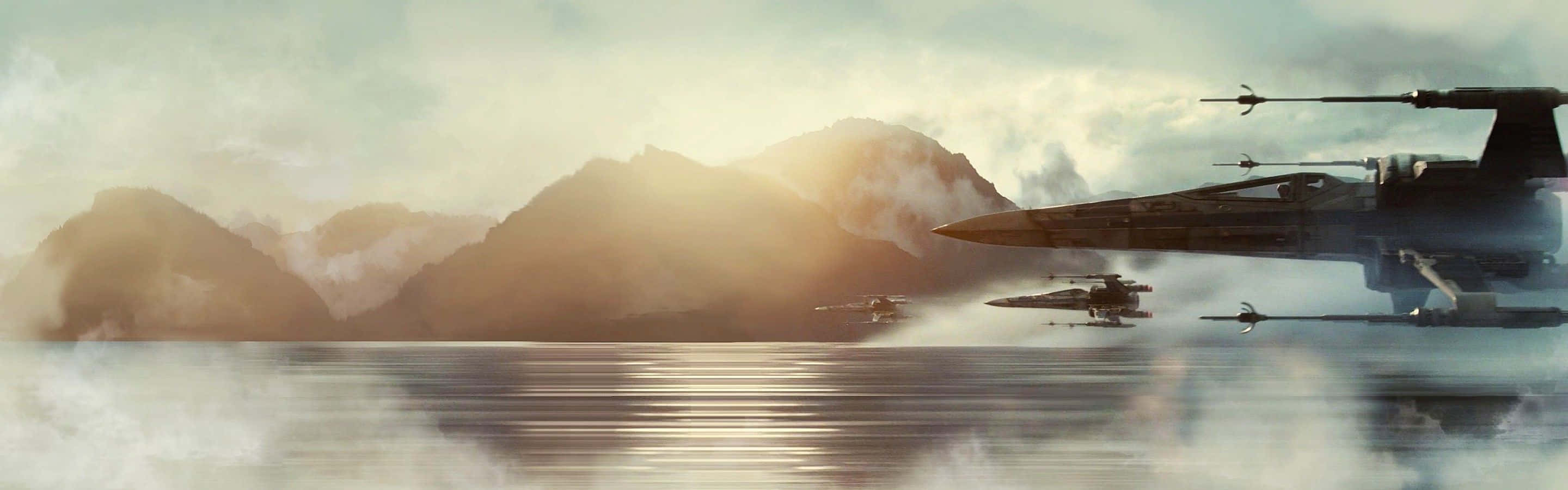 Scarif 桌布 壁紙 — X-wing 戰機在黎明時分飛越霧氣籠罩的山脈，在金色光芒下平靜的水面上倒映。