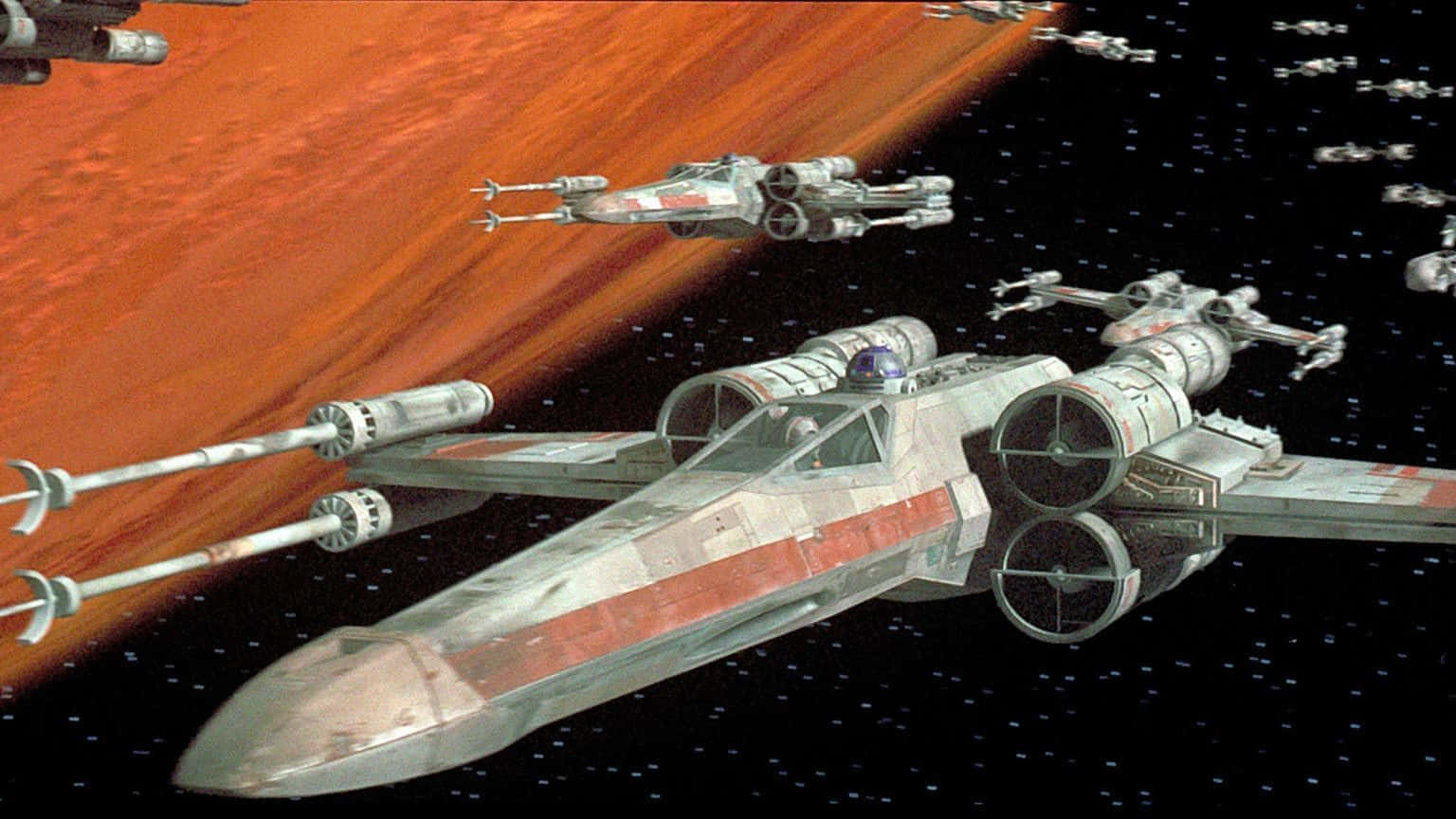 The Z-95 Headhunter 桌布 壁紙 — X-wing 星際戰鬥機在繁星點點的太空翱翔，靠近一顆巨大的紅色行星，遠方有艦艇編隊。