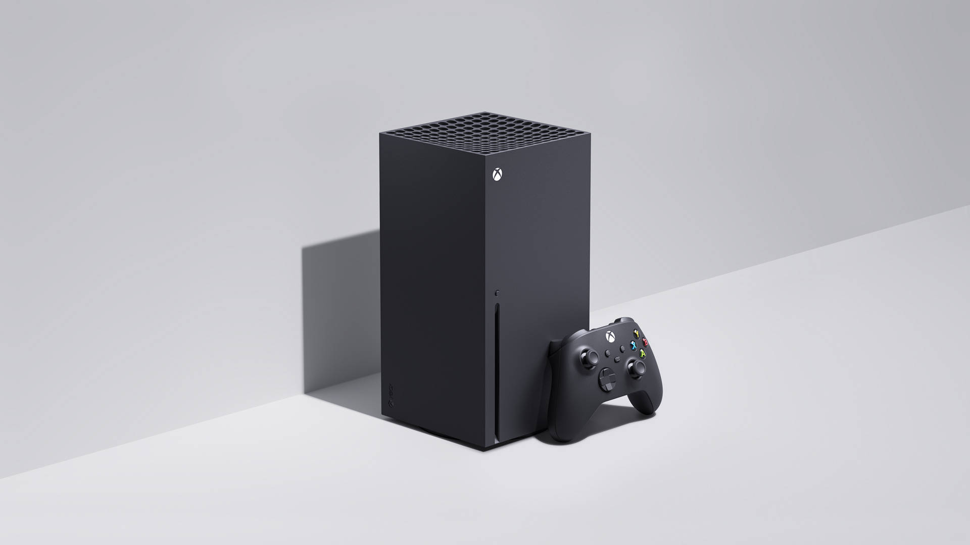 黑白 Xbox One X 壁紙 — 一部時尚的黑色 Xbox Series X 主機和手掣放在簡約的白色表面上，帶有柔和陰影。