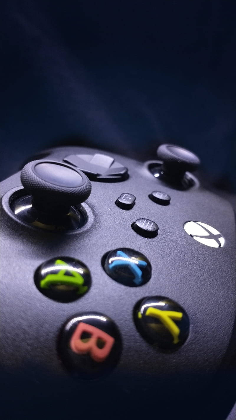 Xbox Series X 控制器特寫 壁紙 — 黑色Xbox手掣嘅特寫，帶有發光嘅彩色按鈕，背景係深色。