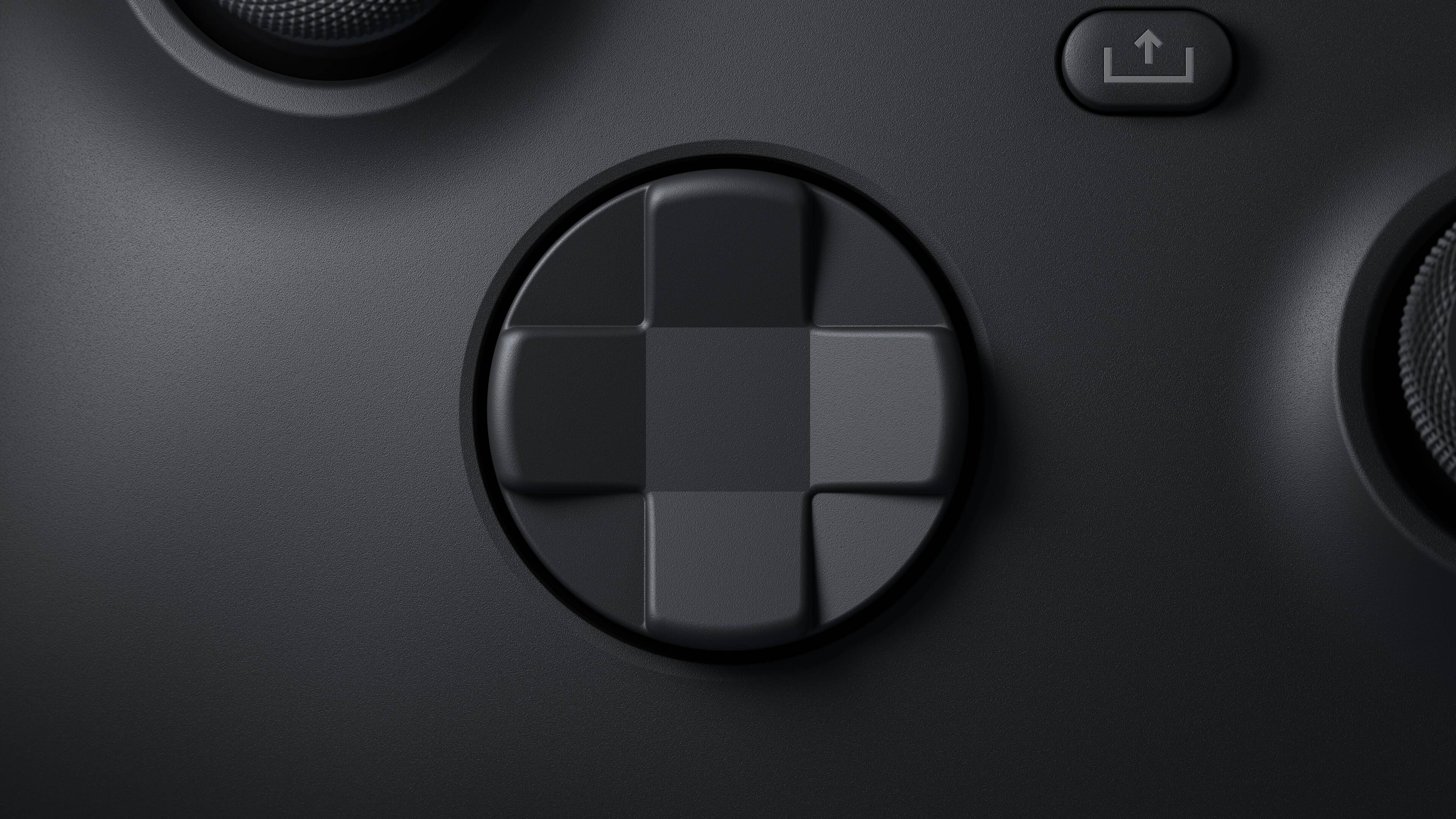 Xbox Series X 方向鍵 壁紙 — 啞光黑色遊戲控制器方向鍵的特寫，帶有微妙的燈光高光。