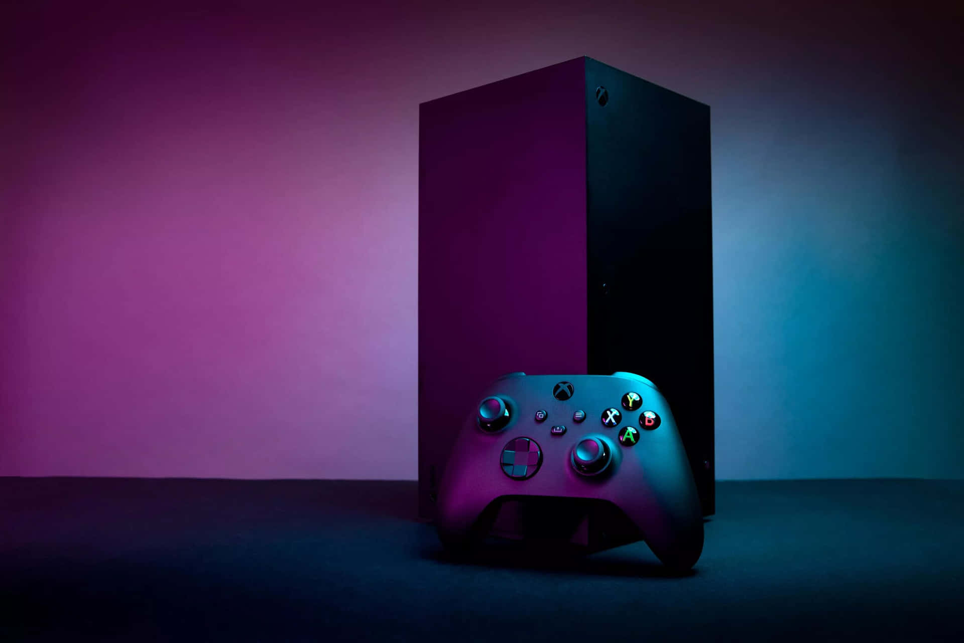 在工作室環境中，Xbox主機和控制器被紫色和藍色燈光照亮。