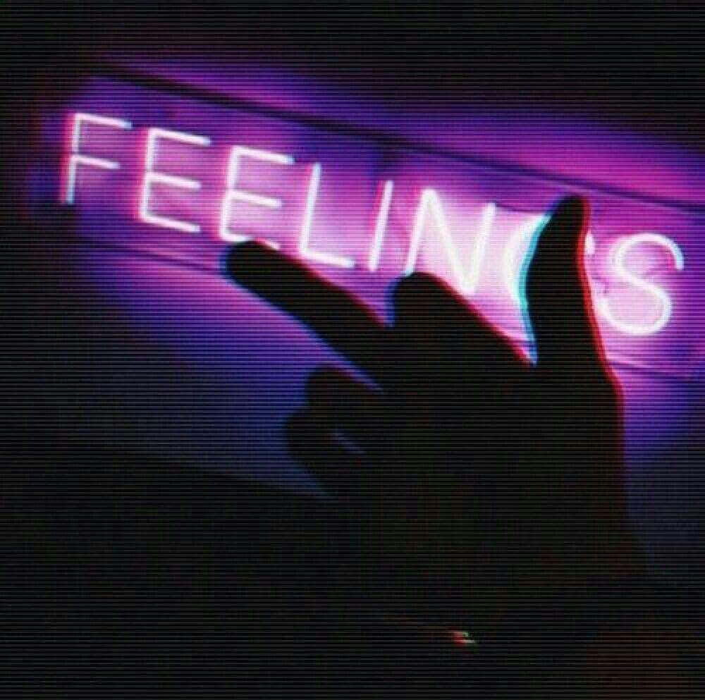 手在發光的紫色霓虹燈牌前做出和平手勢，牌上寫著 FEELINGS。