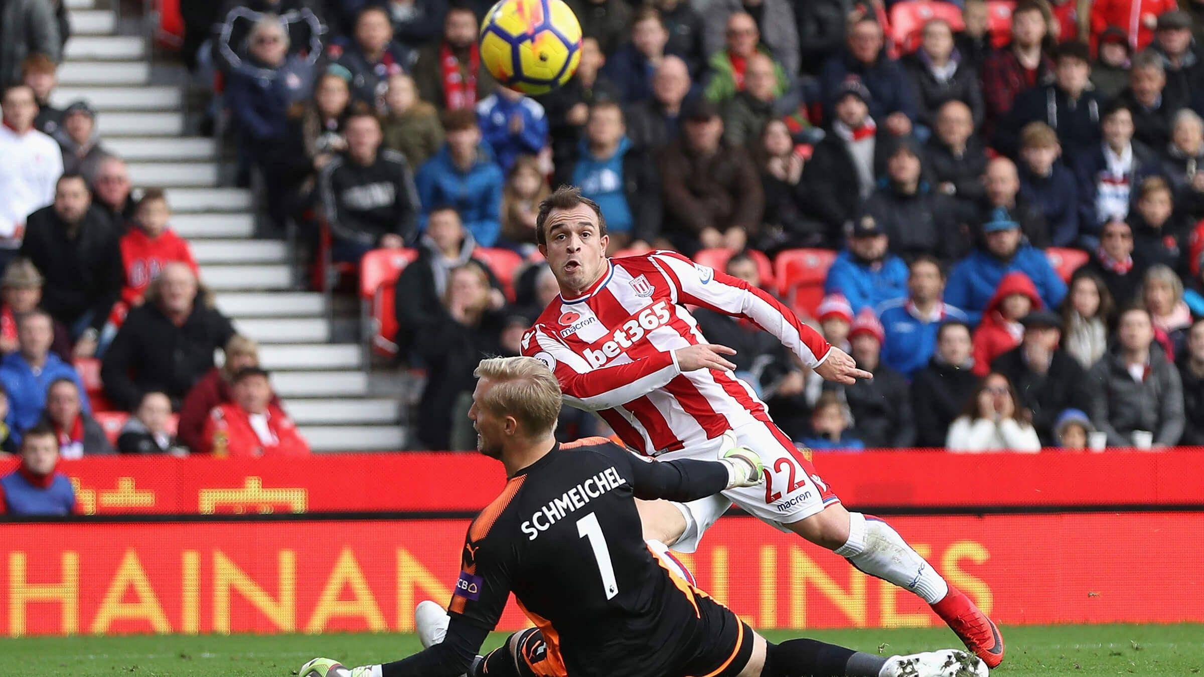 Xherdan Shaqiri 對決 D.C. 聯合隊 壁紙 — 一名身穿紅白間條的足球員跳起頂球，而身穿黑色的守門員則飛身撲救。
