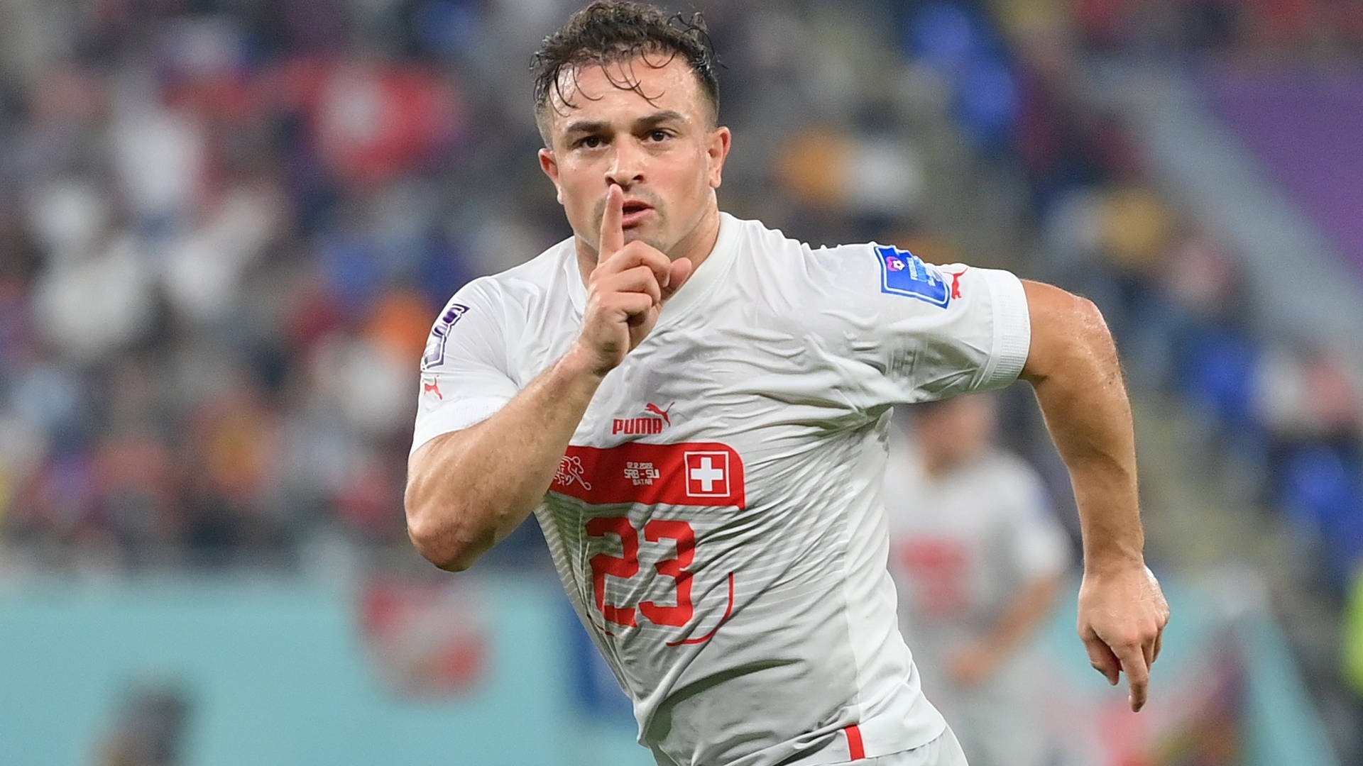 Xherdan Shaqiri 芝加哥火車隊邊鋒全速衝刺 壁紙 — 一名身穿白色球衣、帶有紅十字和23號的瑞士足球員在場上奔跑，做出手指放在嘴唇上的手勢。
