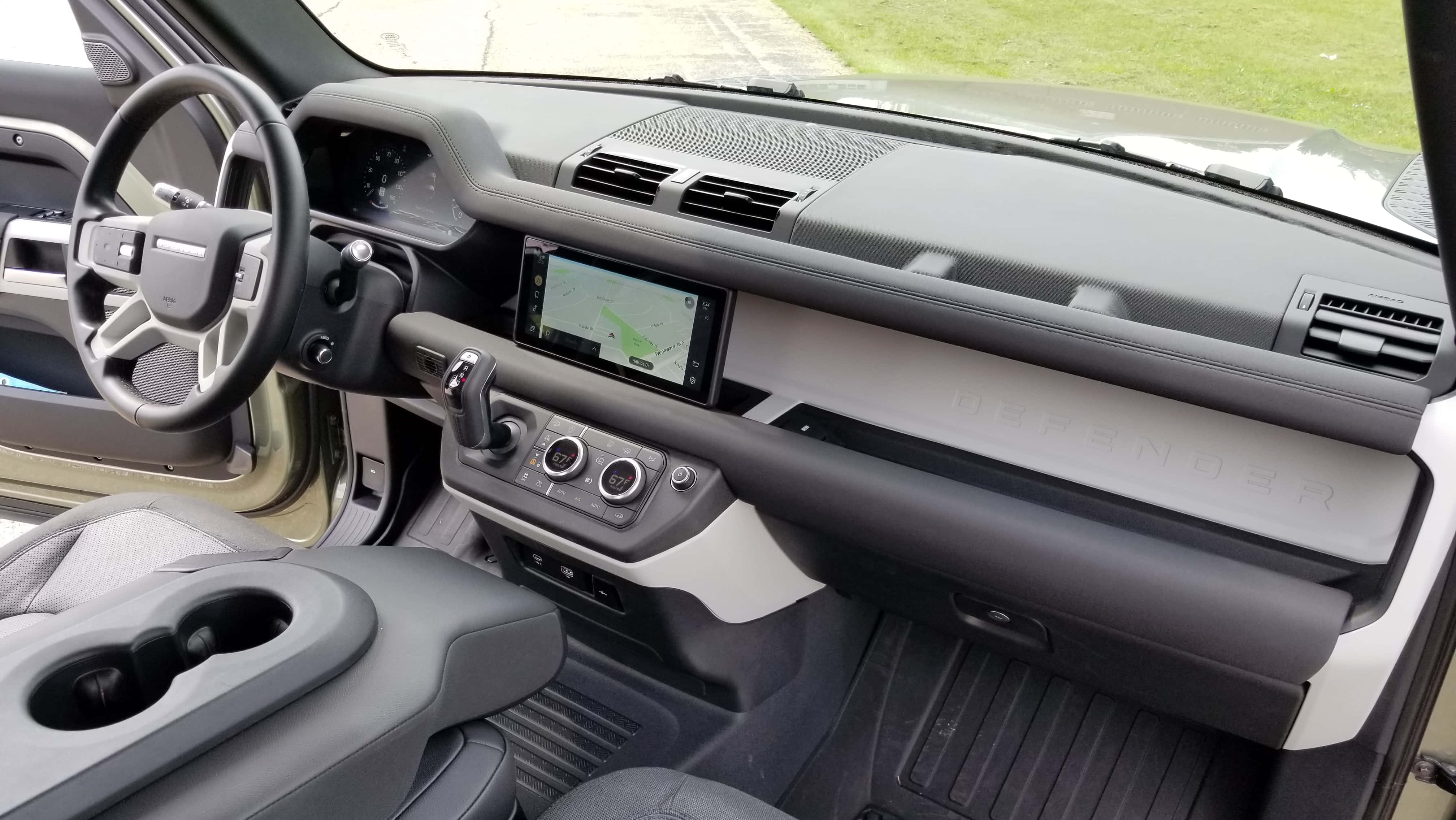 Land Rover Defender 桌布 壁紙 — 現代路虎衛士內飾特寫展示黑色方向盤、中控屏和灰色皮革座椅