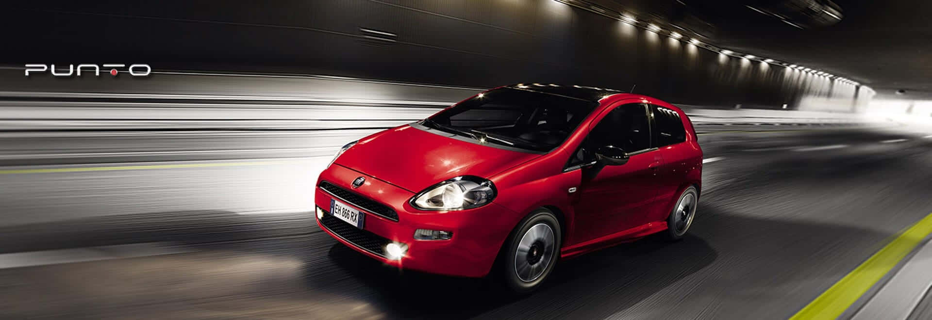 Fiat Punto 桌布 壁紙 — 一輛鮮紅色的快意Punto在昏暗的隧道中疾馳，帶有動態模糊效果。