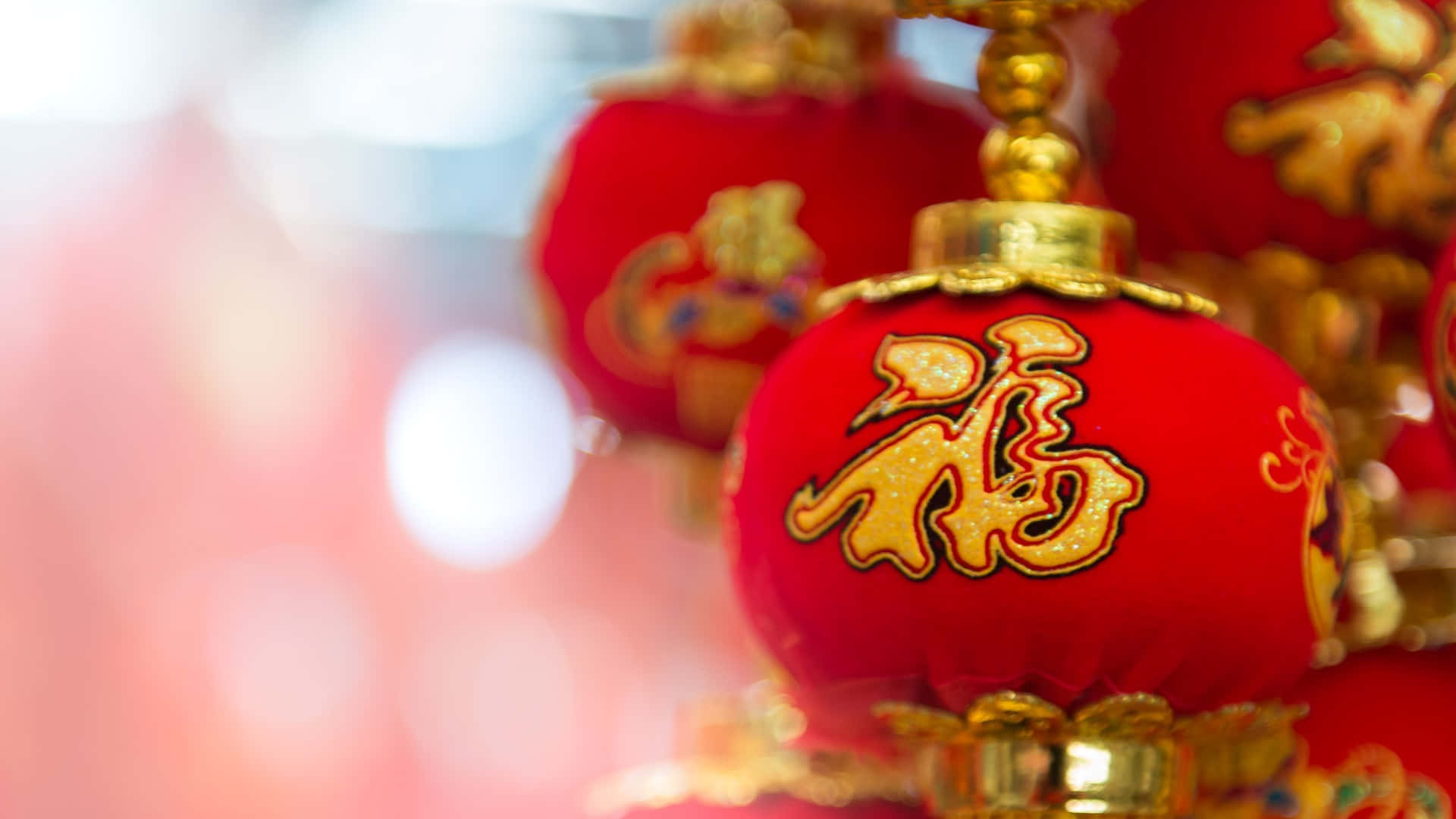  壁紙 — 鮮豔的紅色中國燈籠帶有金色的「福」字，在模糊的節日背景中柔和地發光。