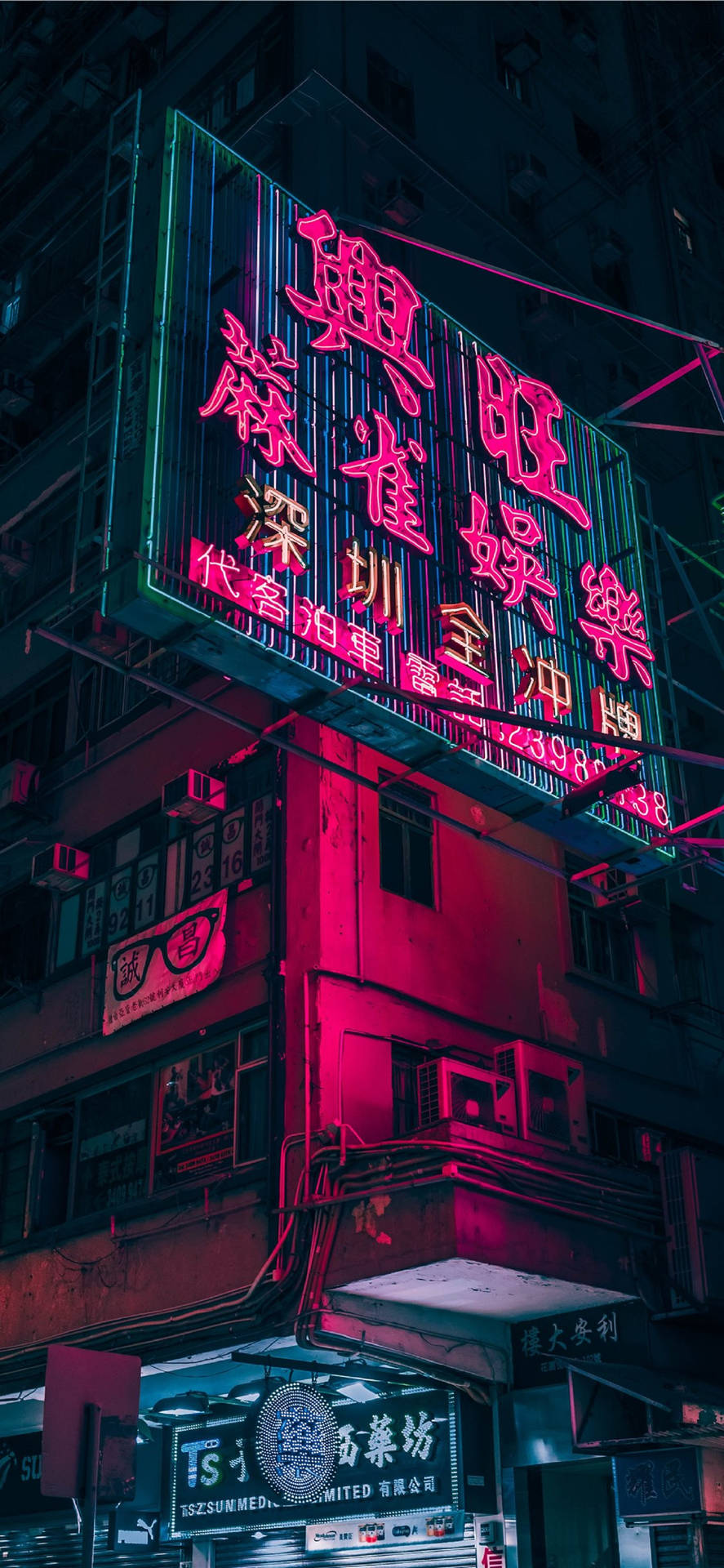 霓虹燈在夜間用粉紅色和綠色的燈光照亮城市建築。