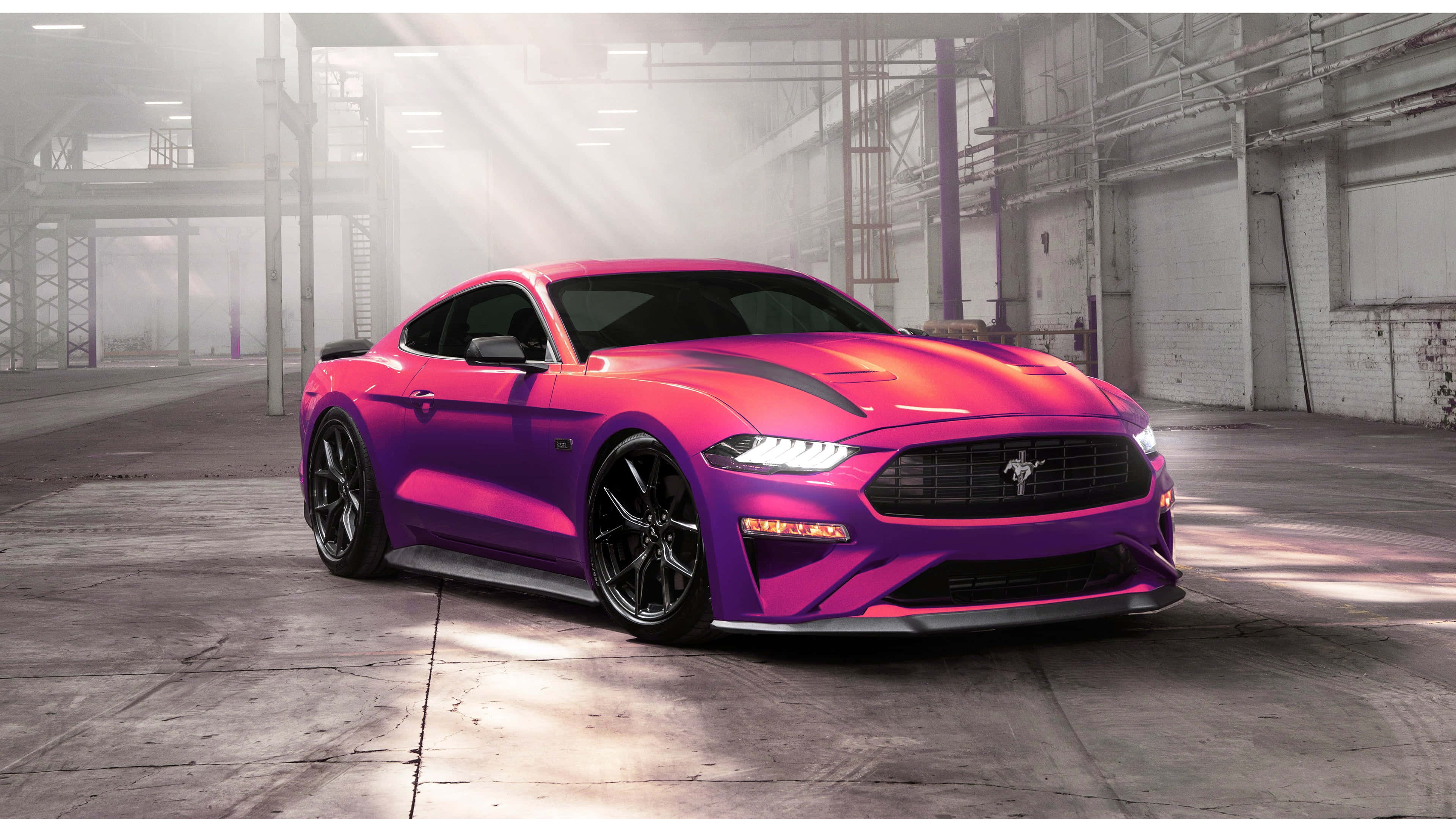 Ford Mustang Ecoboost 桌布 壁紙 — 一輛鮮豔的洋紅色和紫色福特野馬跑車在塵土飛揚的工業倉庫內，在戲劇性的燈光下閃閃發光。