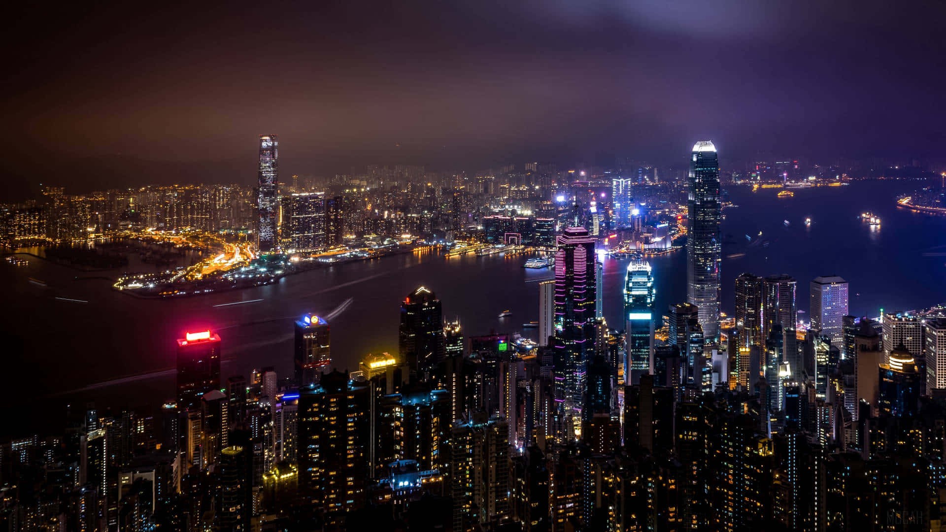  壁紙 — 香港令人驚嘆的夜景，摩天大樓閃爍光芒，黑暗天空下充滿活力的港口。