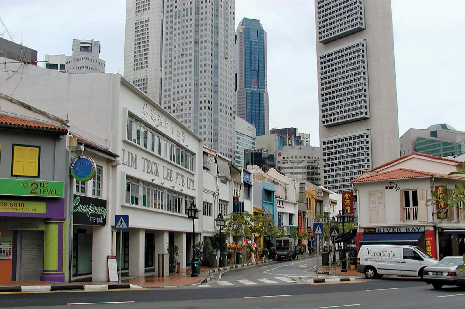 新加坡的城市街道，擁有殖民時期店屋和現代摩天大樓。