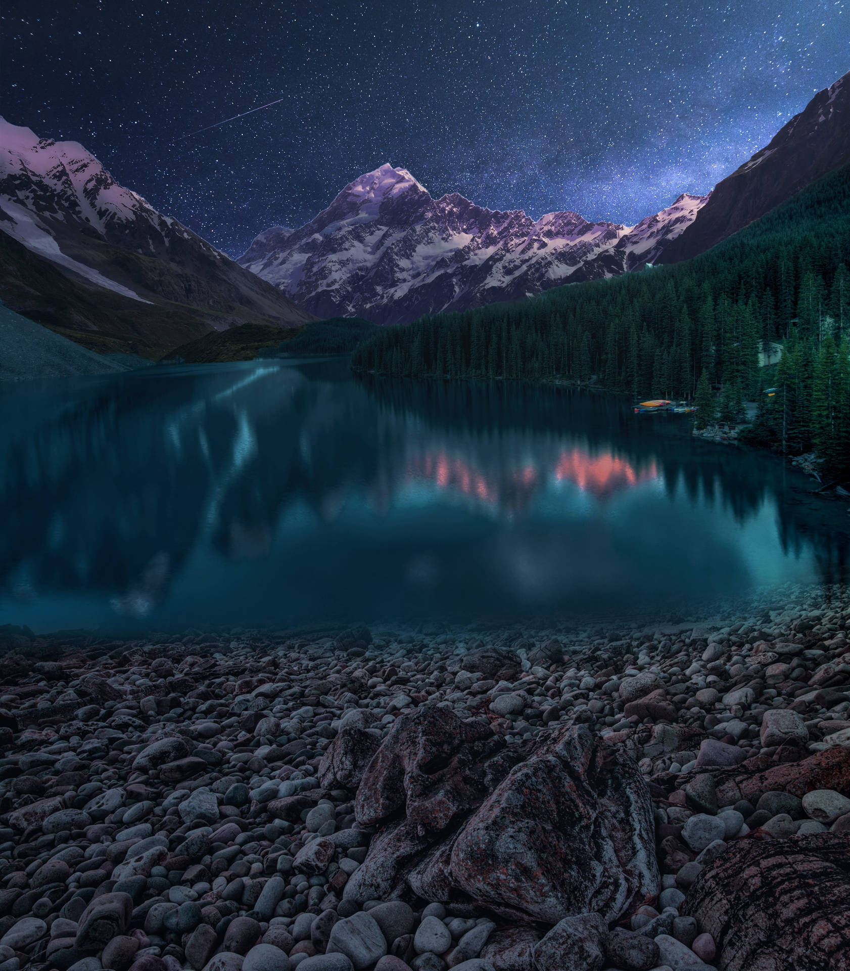 星空下的山湖，有積雪的山峰和森林倒影。