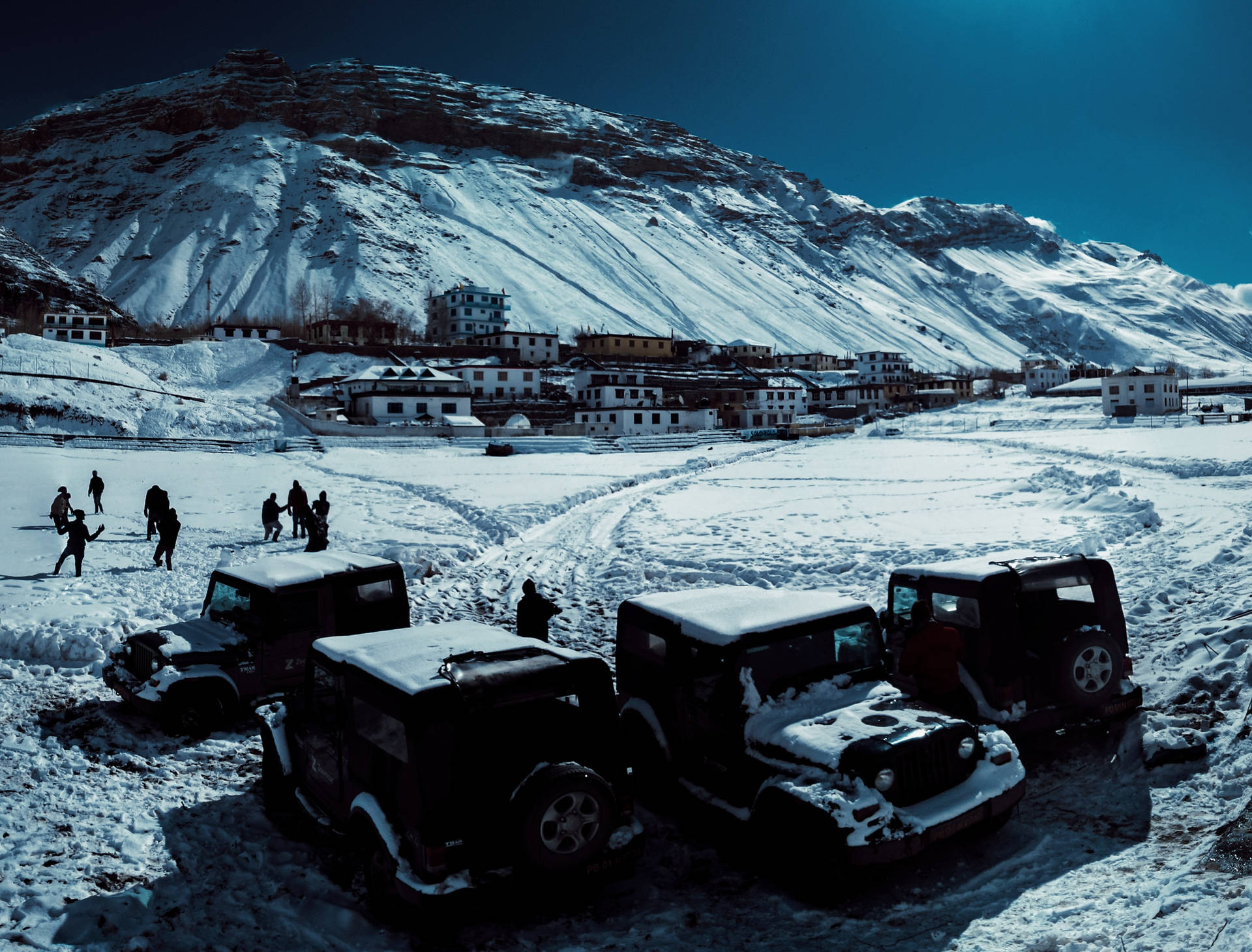 白雪覆蓋的山村，停放的吉普車和玩雪的孩子們。