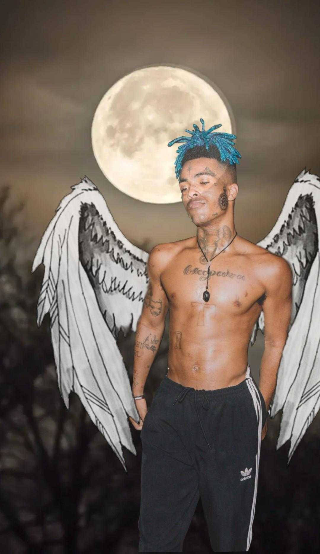 滿月下藍色頭髮同天使翅膀嘅男人。