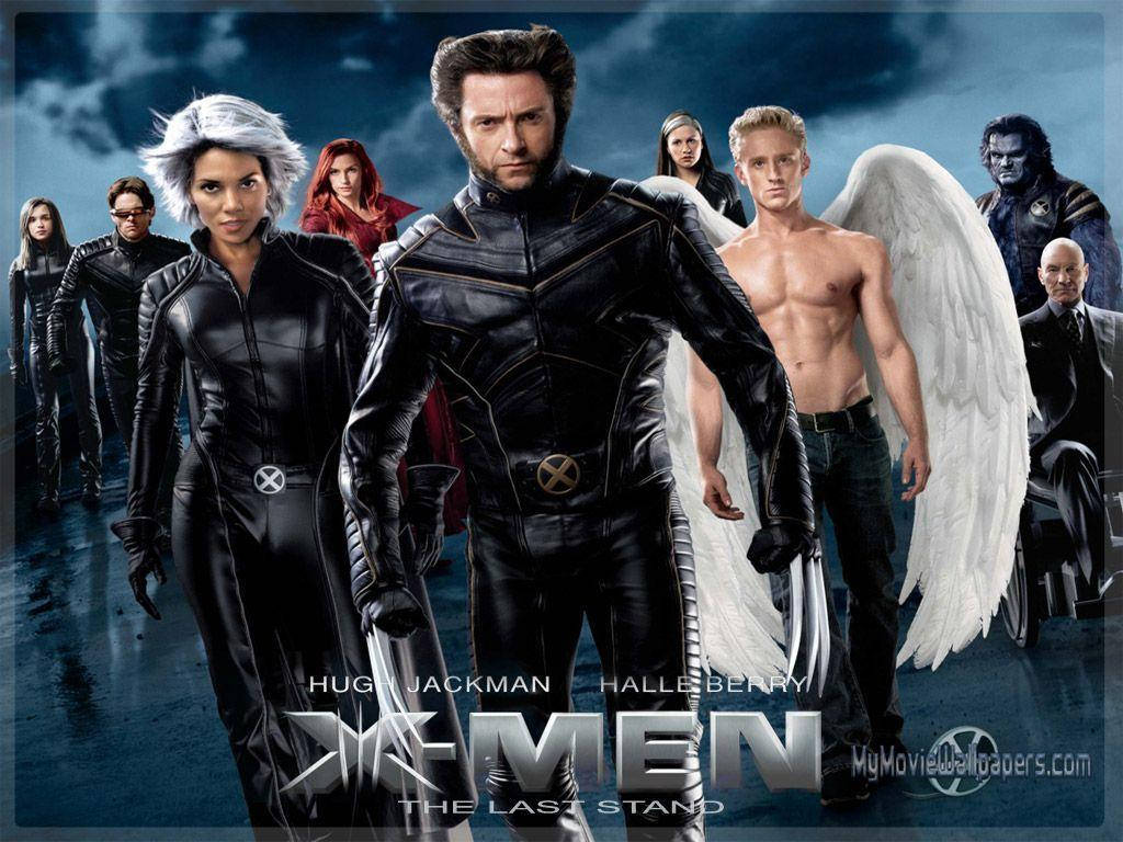 X戰警 電影 壁紙 — X-Men 團隊英勇地站在黑暗的暴風雨中，金剛狼在前，天使的白色翅膀張開。