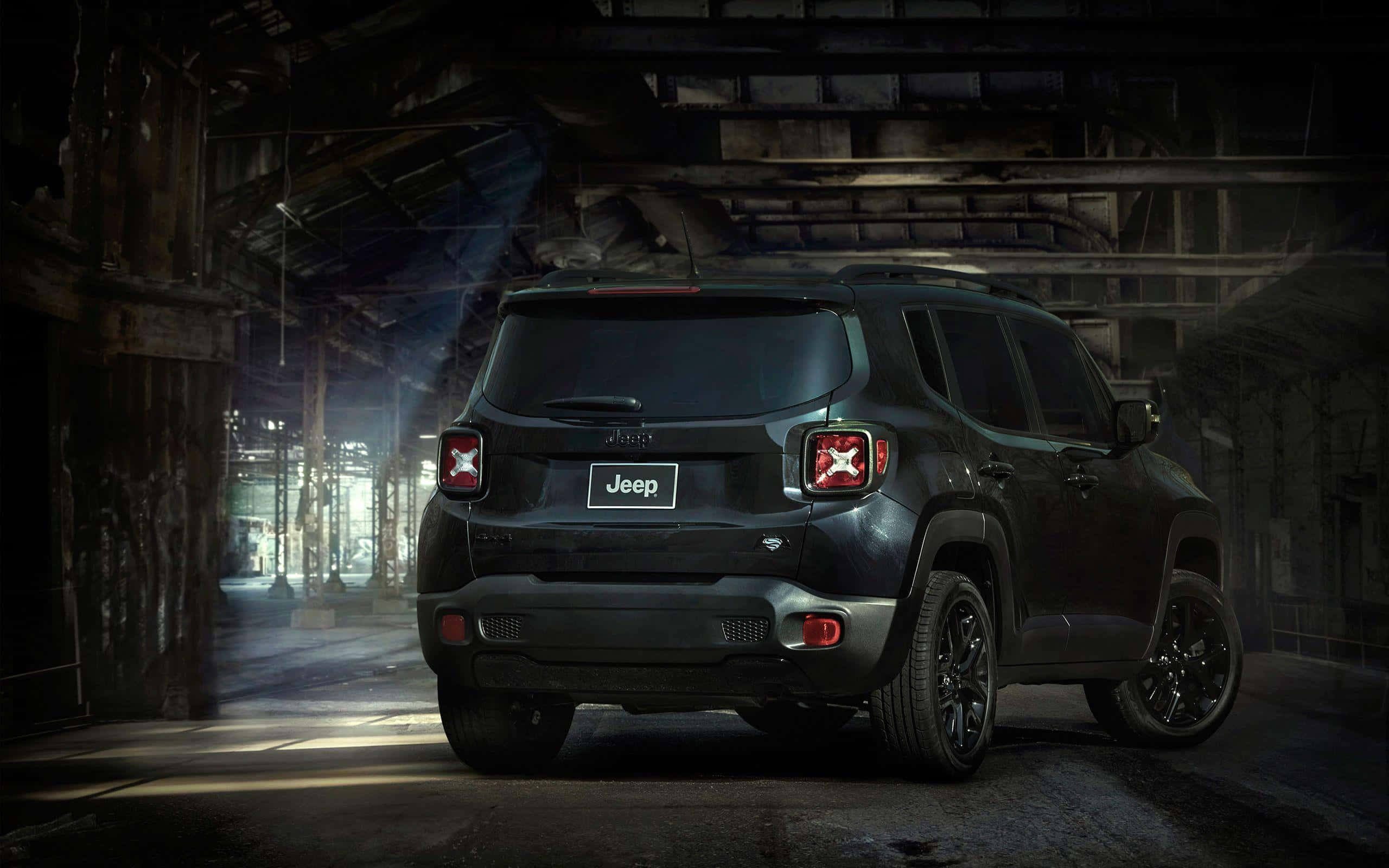 Jeep Renegade 桌布 壁紙 — 一輛啞光黑色Jeep Renegade停放在光線昏暗的廢棄倉庫中，戲劇性的光束穿過灰塵。