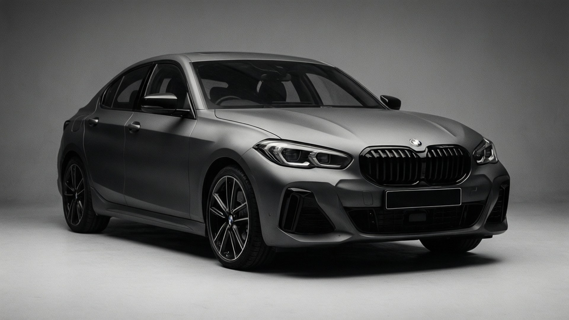 Bmw 1 Series 桌布 壁紙 — 一輛時尚的啞光灰色BMW轎車在簡約的工作室中擺拍，柔和燈光凸顯其現代設計。