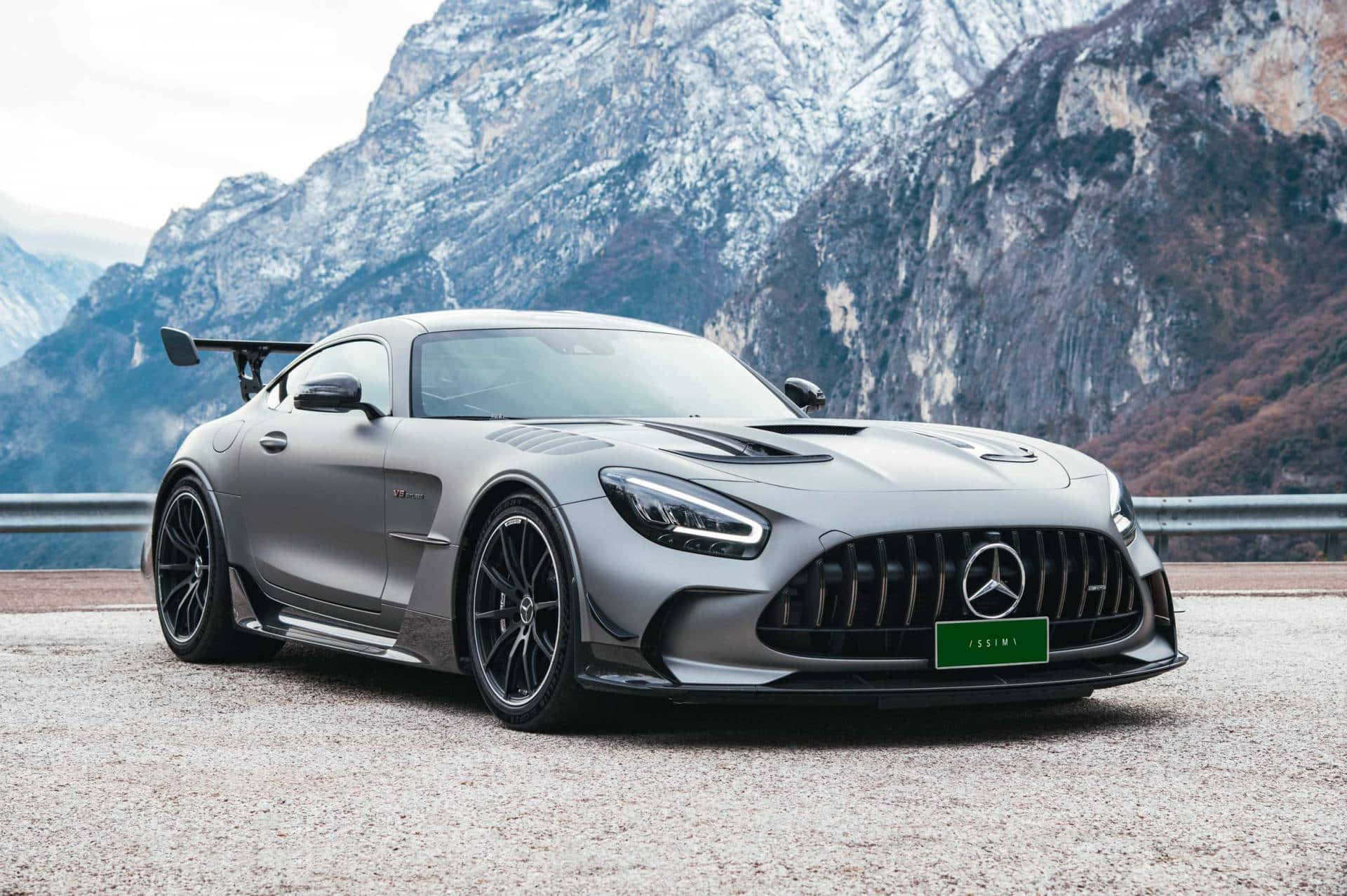 Mercedes Benz Amg Gt 桌布 壁紙 — 一架啞光灰色的 Mercedes-AMG GT Black Series 跑車停泊在山路上，背景是白雪覆蓋的山峰。