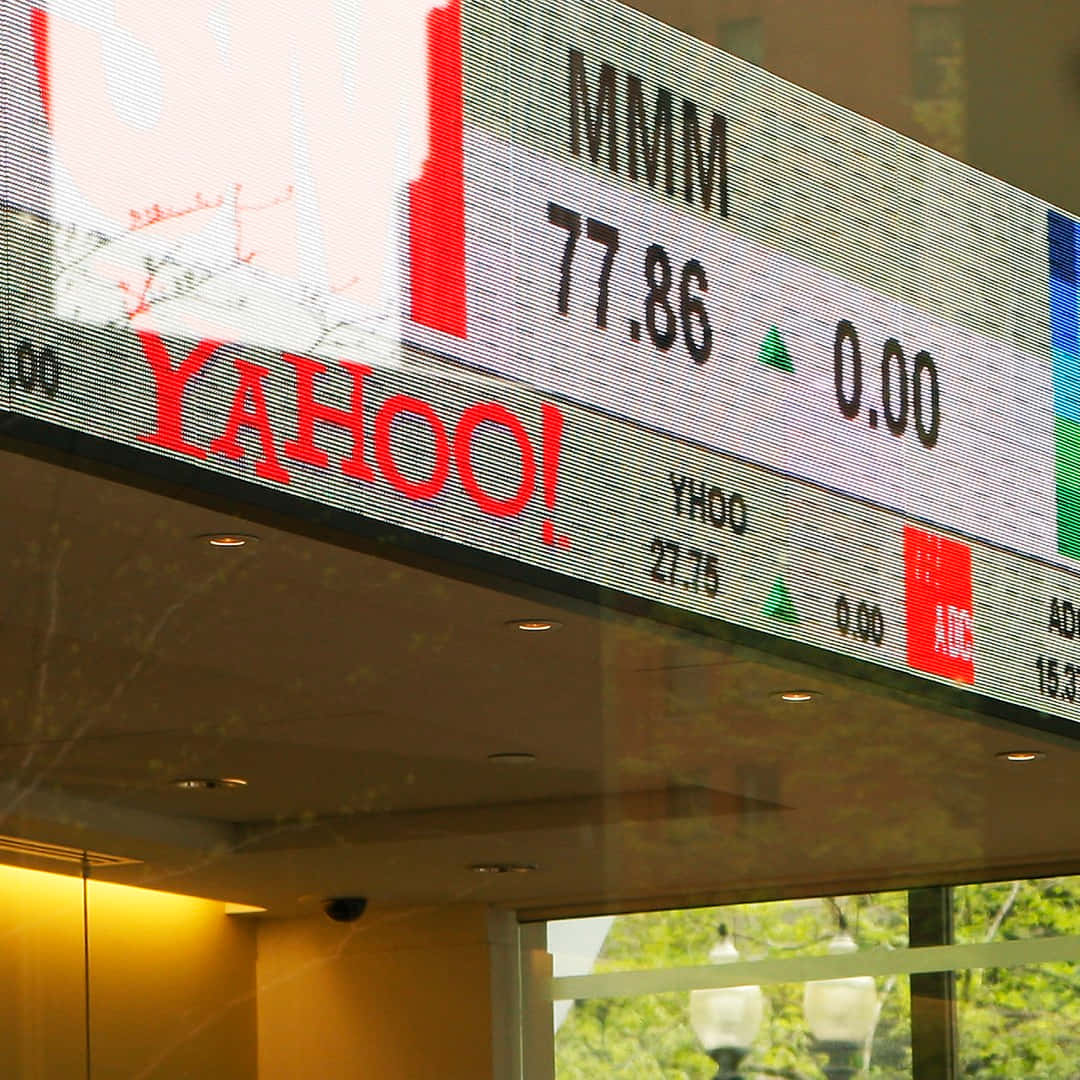 Yahoo!致力協助你探索可能性 壁紙 — 數位股票行情顯示器的特寫，顯示Yahoo和MMM的股價，並有綠色箭頭表示上漲。