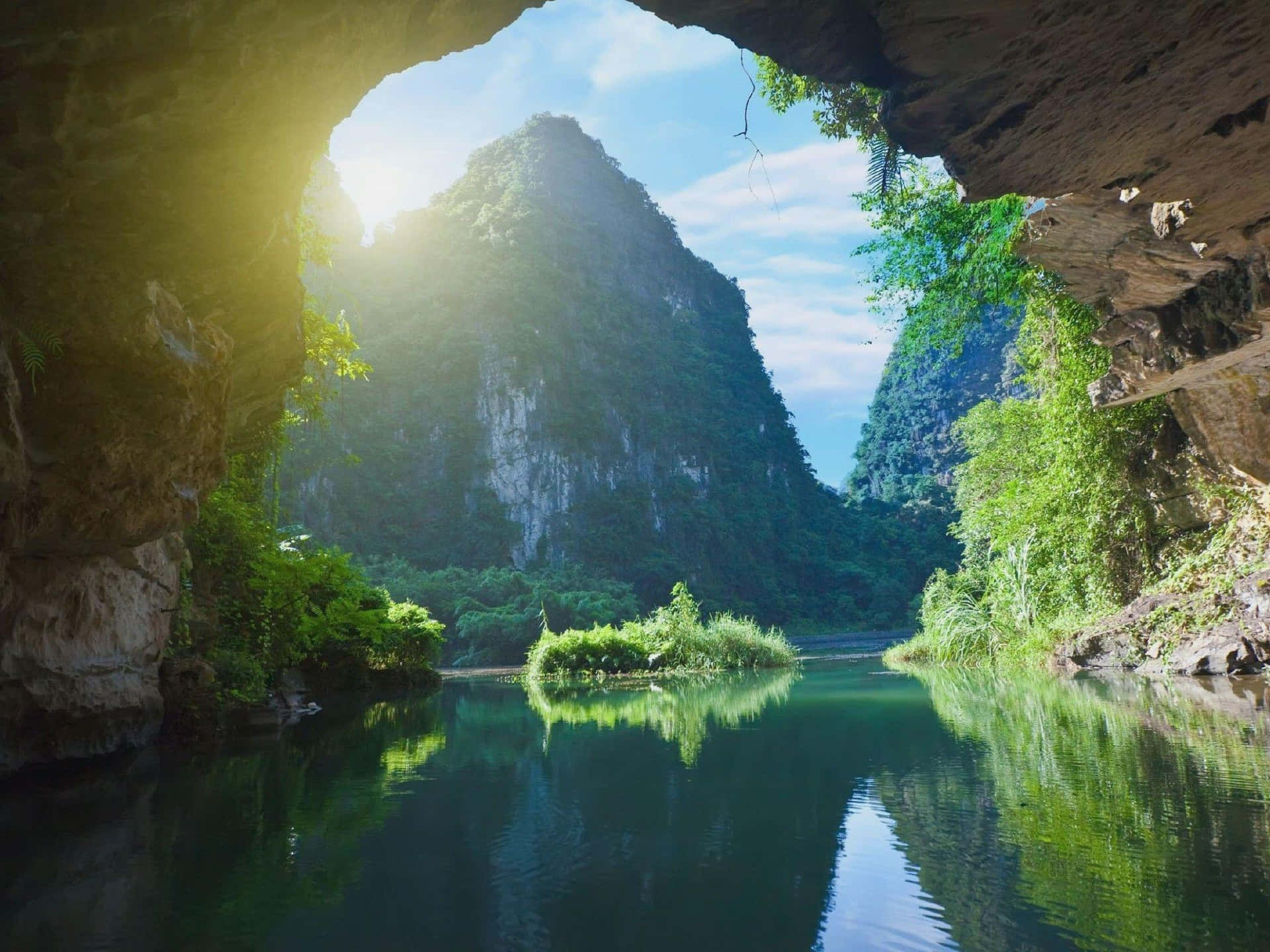 洞穴視角的河流與山脈，陽光與綠意