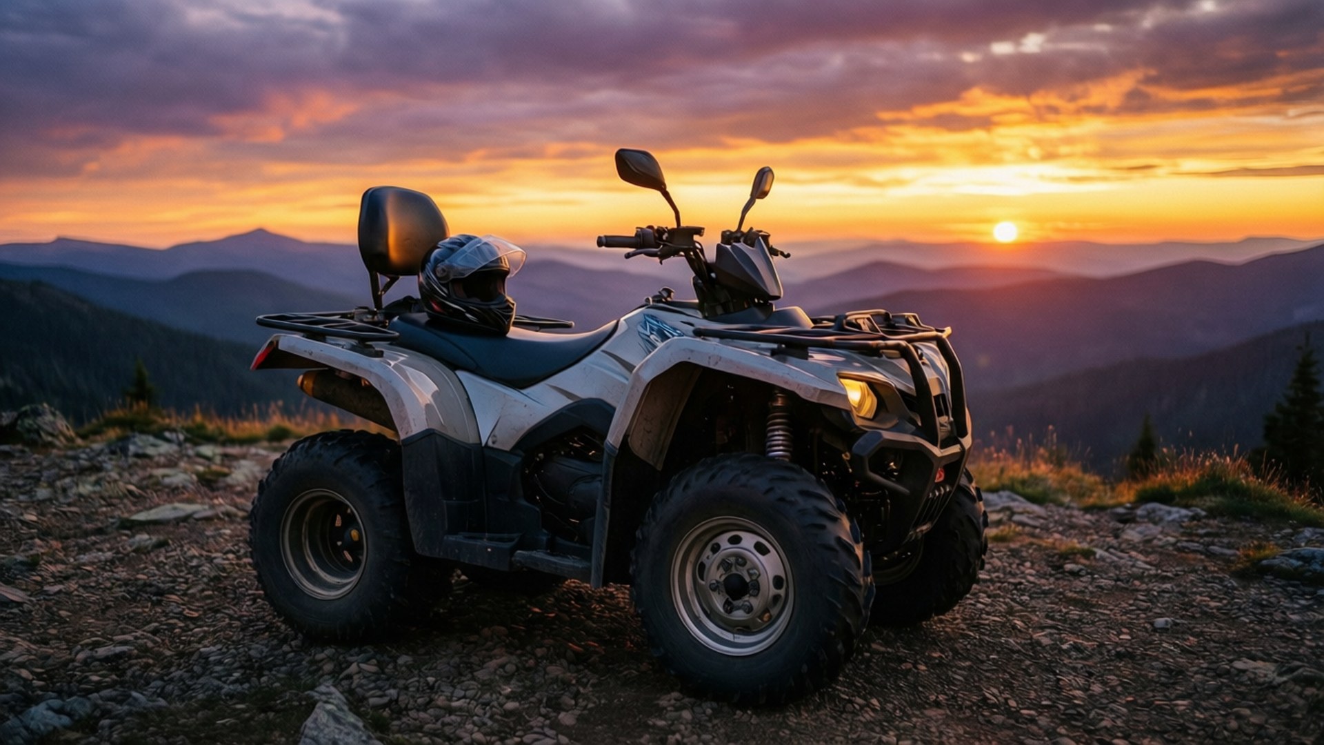 Four Wheelers 桌布 壁紙 — 一架白色ATV停泊在岩石山脊上，日落時分，天空呈現鮮豔的橙色和紫色，遠方層巒疊嶂。