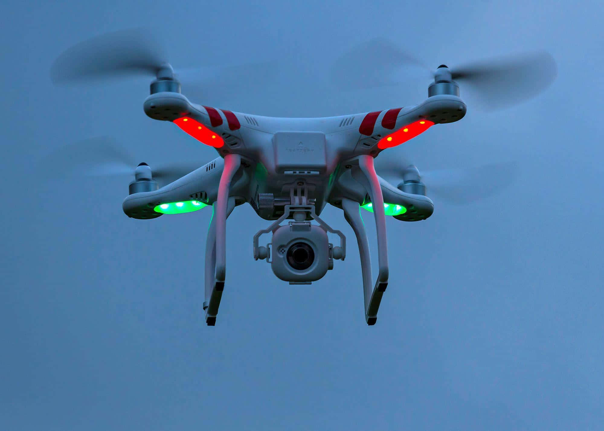 Drone Camera 桌布 壁紙 — 一架帶有紅色和綠色燈光的白色四軸無人機在暮色天空中盤旋。