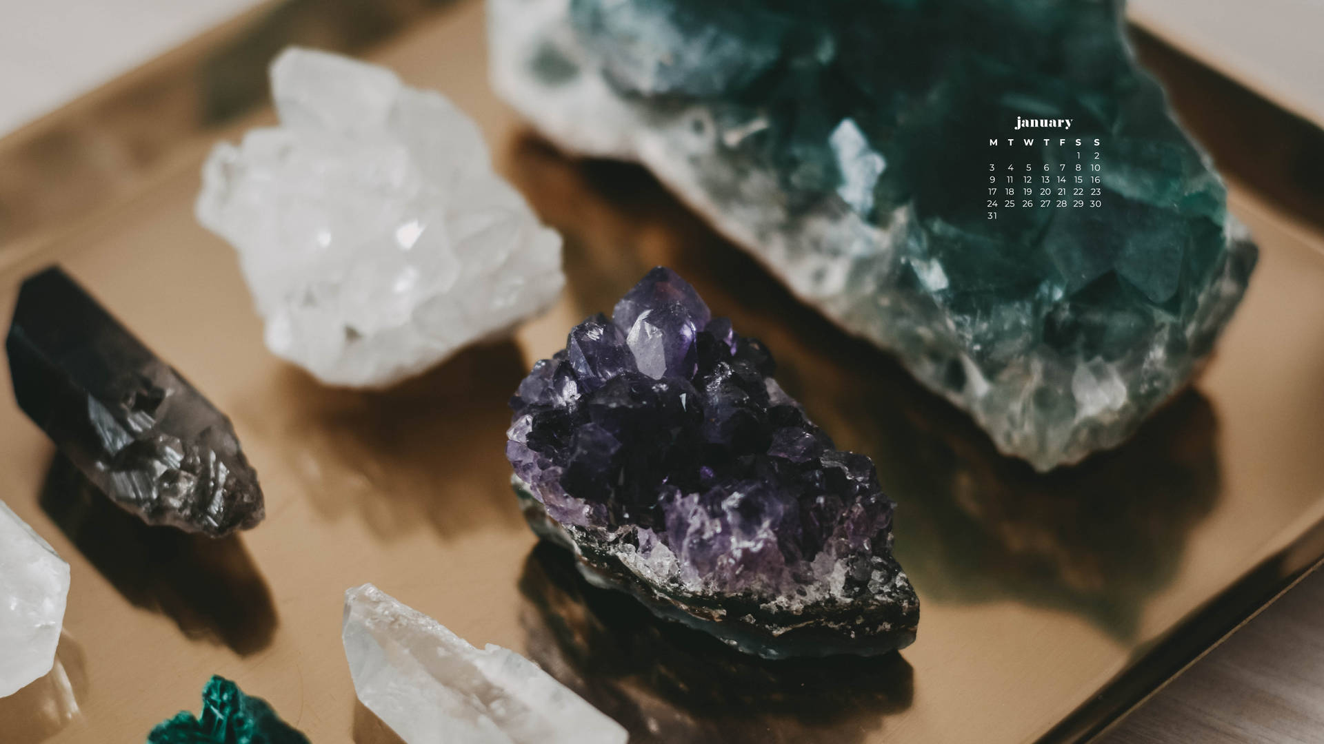 金色托盤上色彩繽紛的水晶收藏，附有一月日曆覆蓋層。