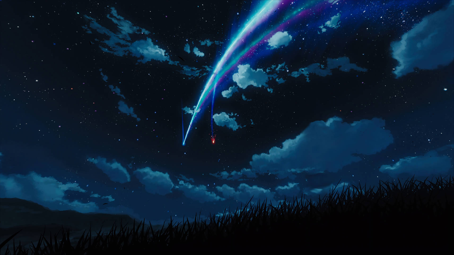 一顆發光的流星在草地上方的星空夜空中劃出一道弧線。