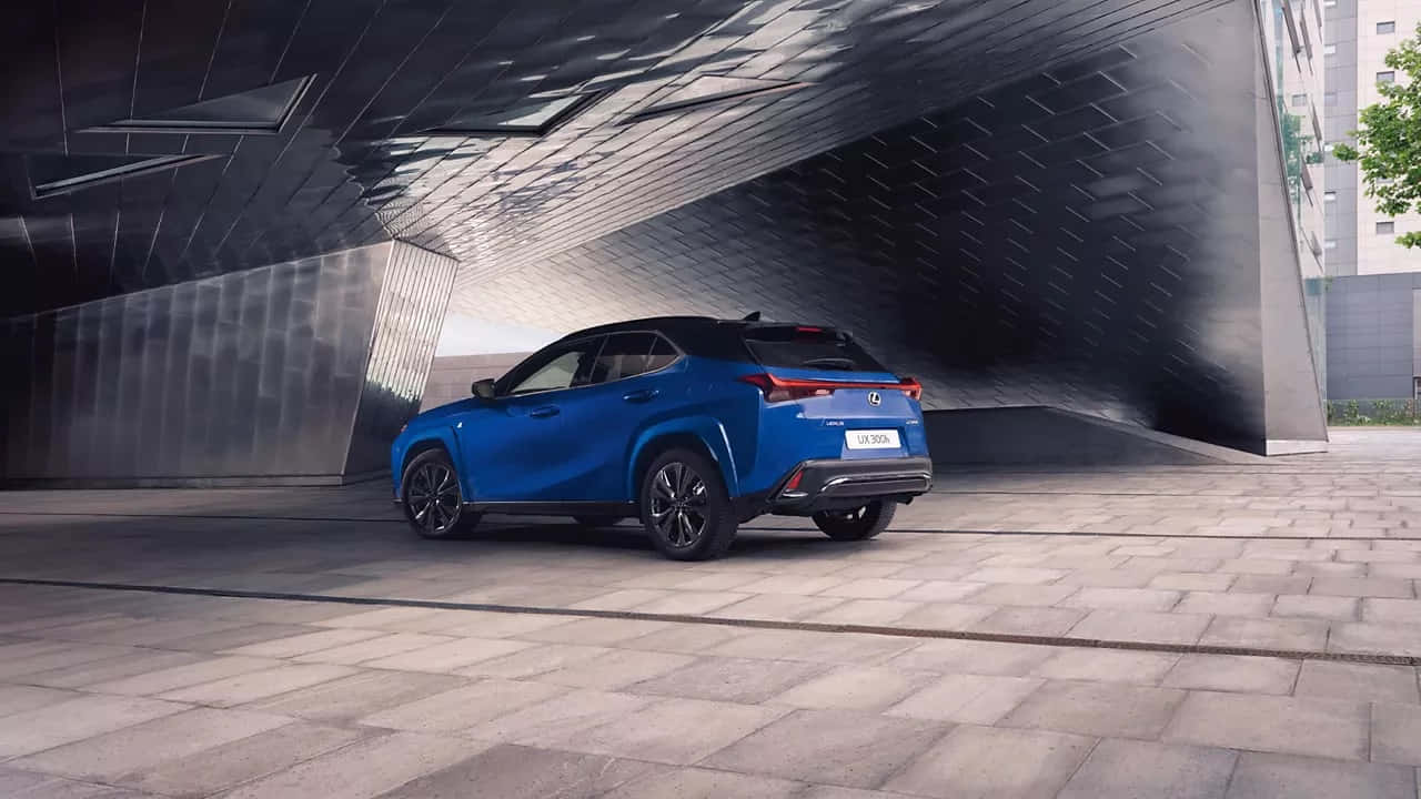  壁紙 — 一輛充滿活力的藍色Lexus UX 300e SUV停放在鋪砌廣場上時尚的金屬建築簷篷下。