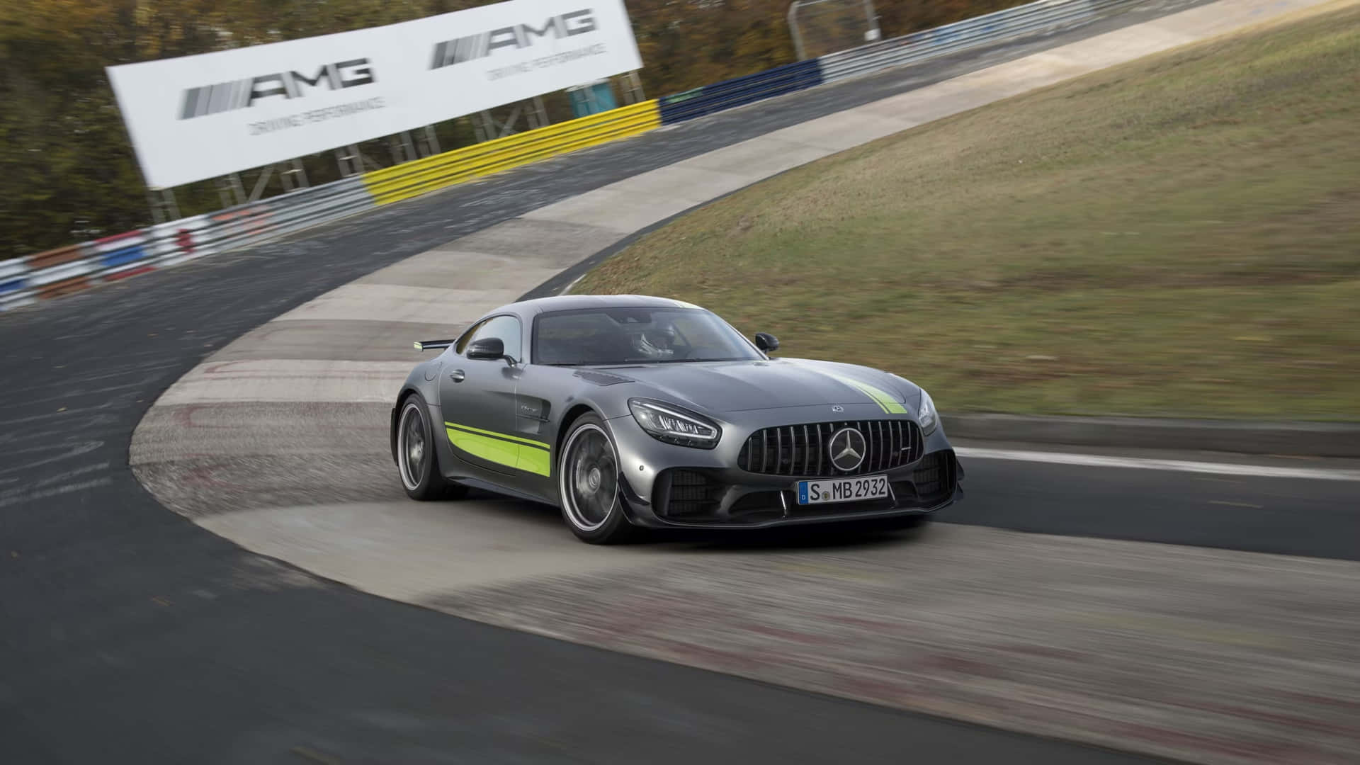  壁紙 — 一輛流線型灰色Mercedes-AMG GT R，帶有螢光綠色點綴，在彎曲賽道上以模糊動態疾馳。
