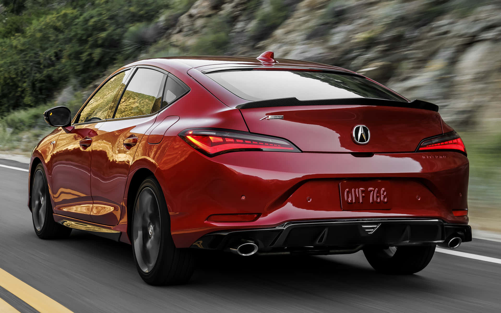 Acura Integra 桌布 壁紙 — 一輛亮紅色Acura TLX運動轎車沿著蜿蜒的山路疾馳，綠意模糊移動。