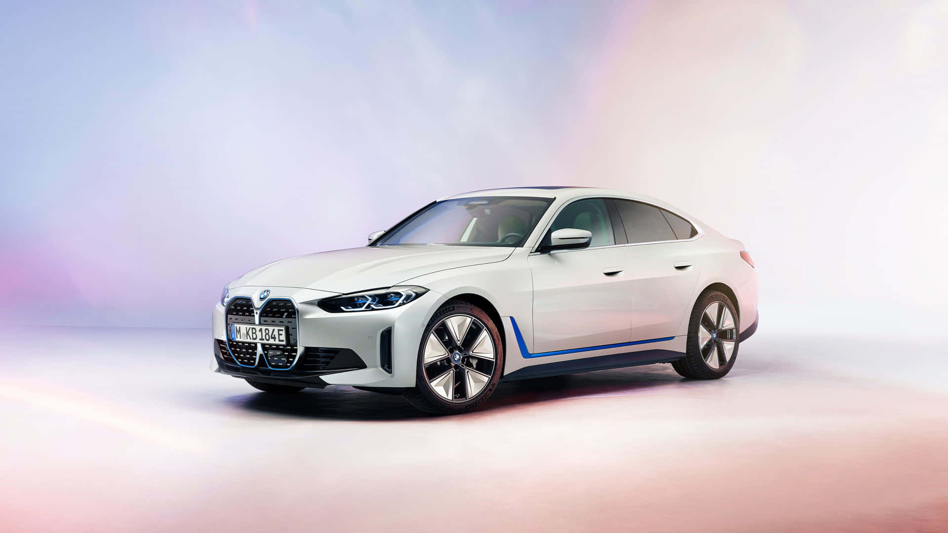 在柔和照明的工作室環境中，帶有藍色飾邊的白色BMW電動車。