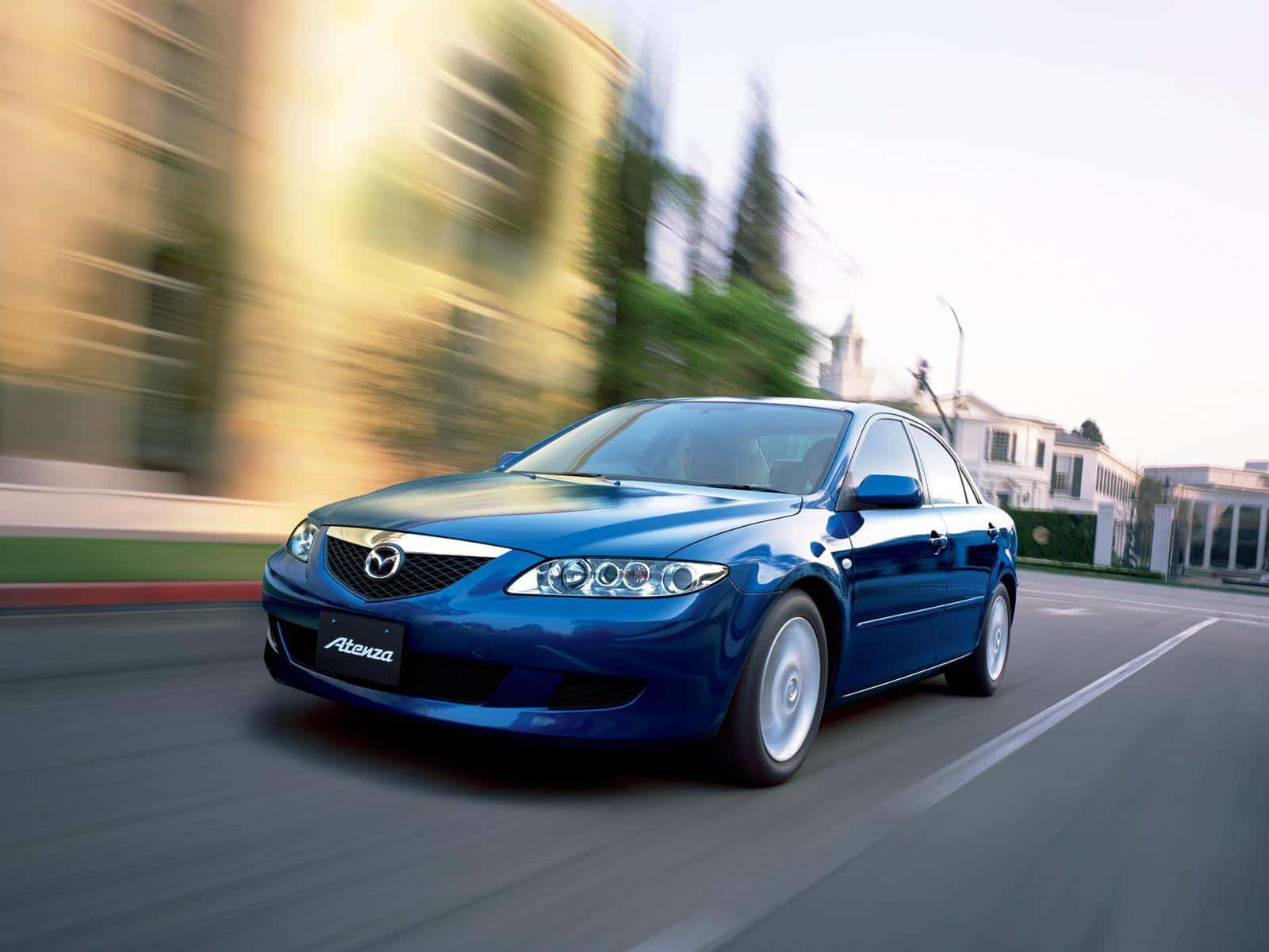 Mazda 6 桌布 壁紙 — 一輛時尚的藍色萬事得 Atenza 在陽光明媚的街道上奔馳，背景呈現動態模糊效果。