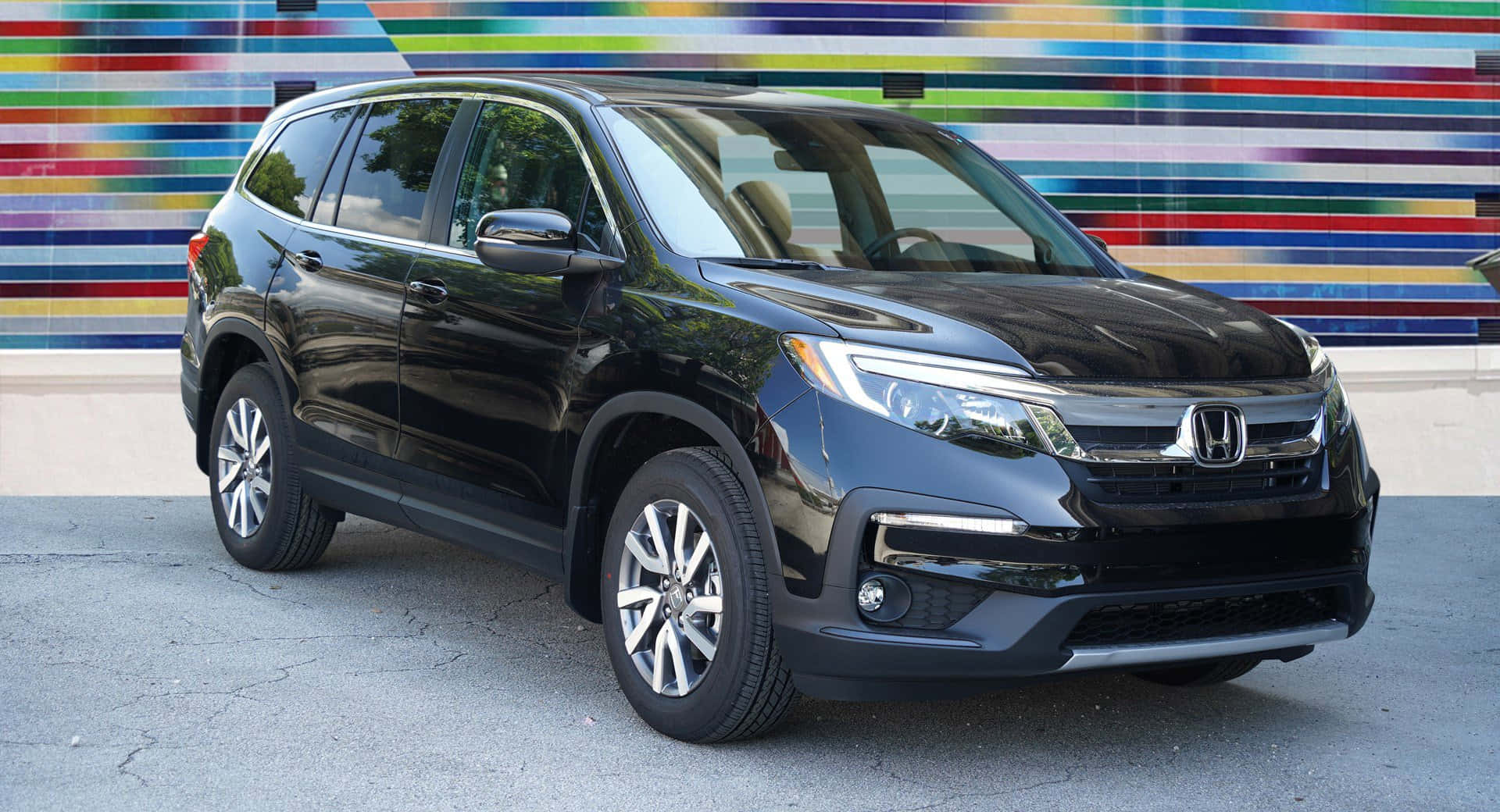 Honda Pilot 桌布 壁紙 — 一輛時尚的黑色本田Pilot SUV停在一幅充滿活力的多色條紋牆前。