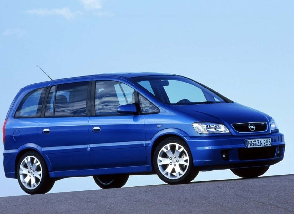 Opel Zafira 桌布 壁紙 — 一輛鮮藍色的Opel Zafira小型貨車停在瀝青路上，天空晴朗，背景是乾淨的攝影棚。