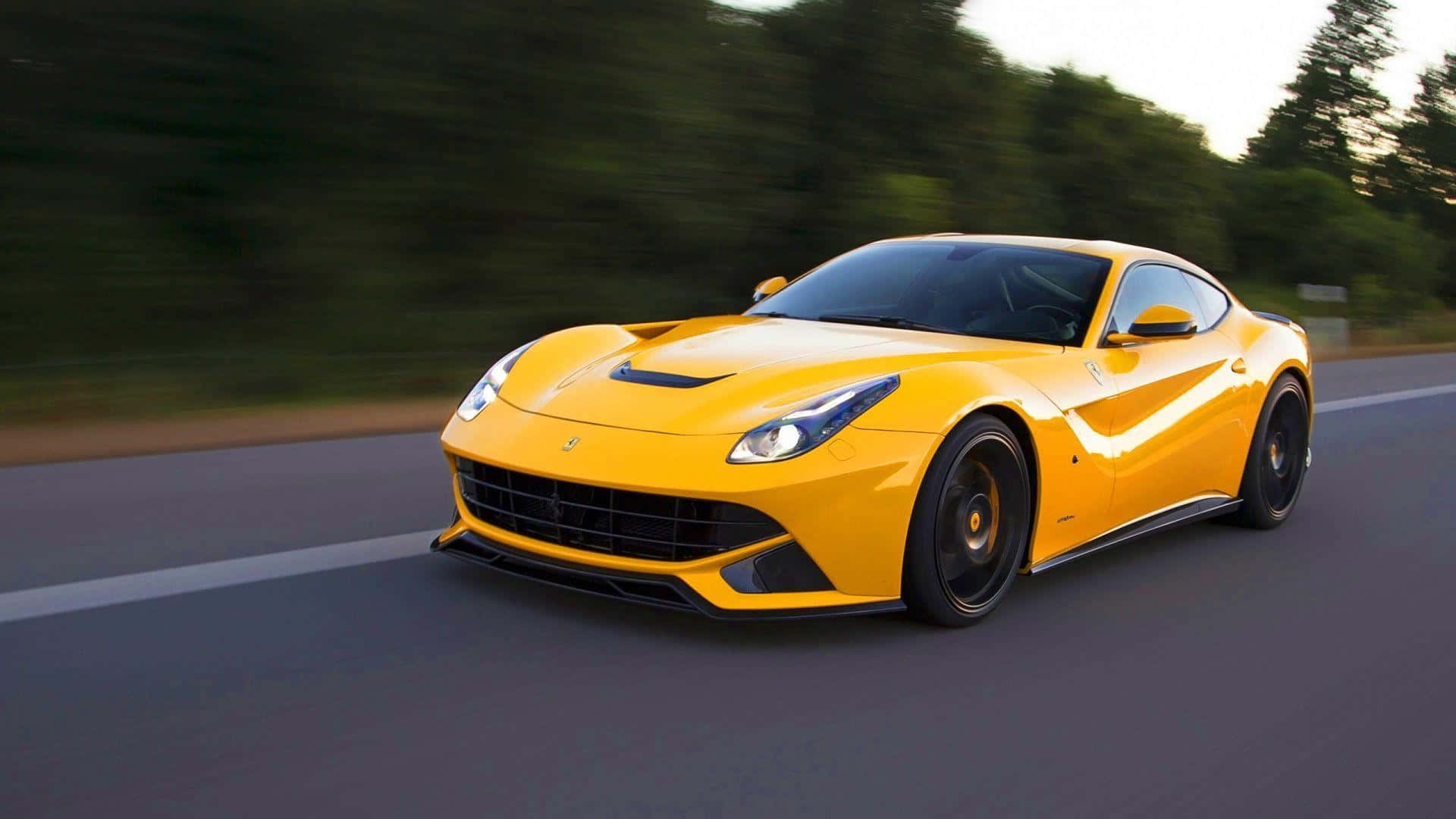 Ferrari F12 Berlinetta 桌布 壁紙 — 一輛充滿活力的黃色法拉利跑車在道路上奔馳，背景是模糊的綠色樹木。