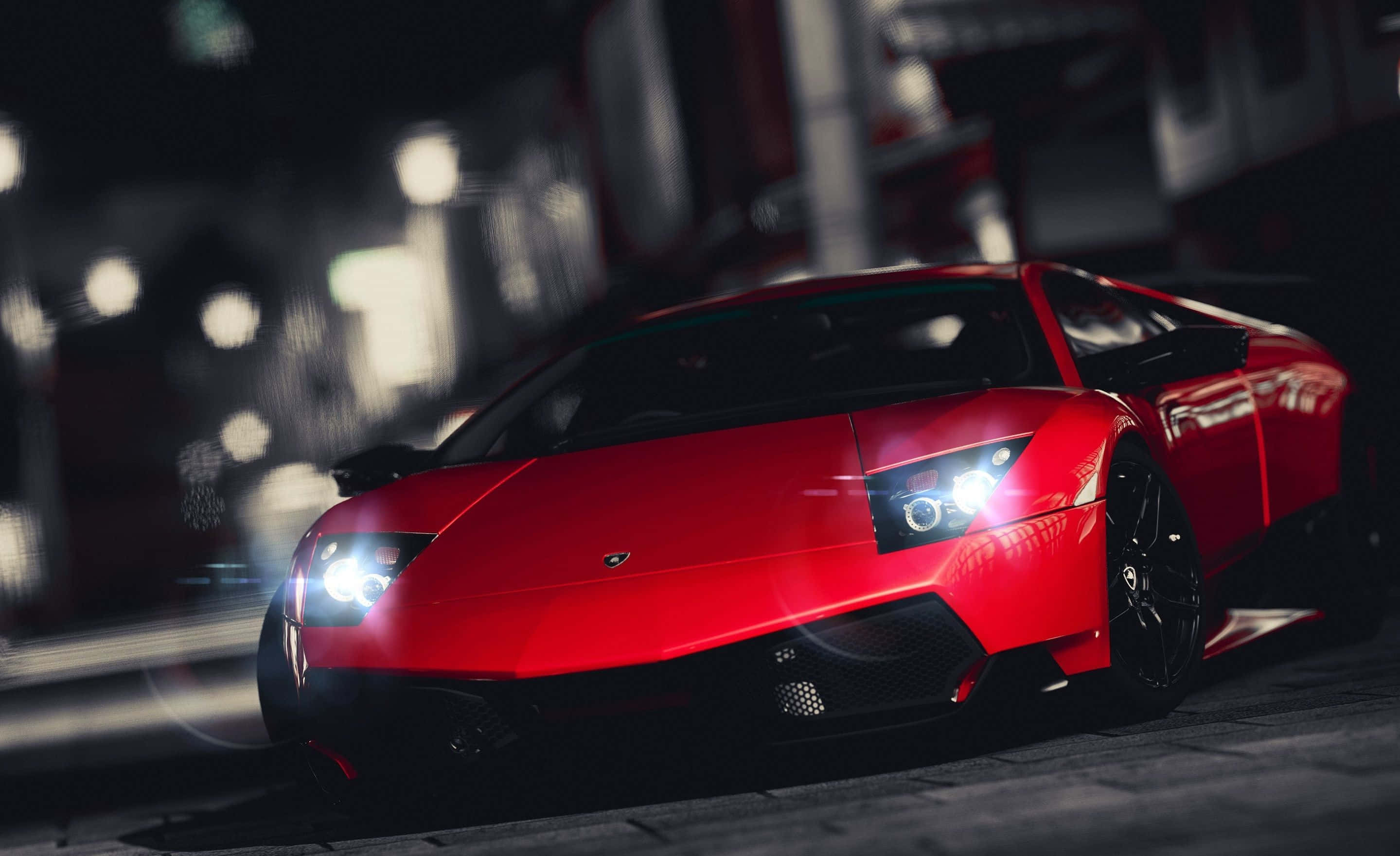 Lamborghini Murciélago 桌布 壁紙 — 一輛鮮紅色的林寶堅尼跑車在夜晚的城市燈光下閃耀，背景是模糊的城市景觀。