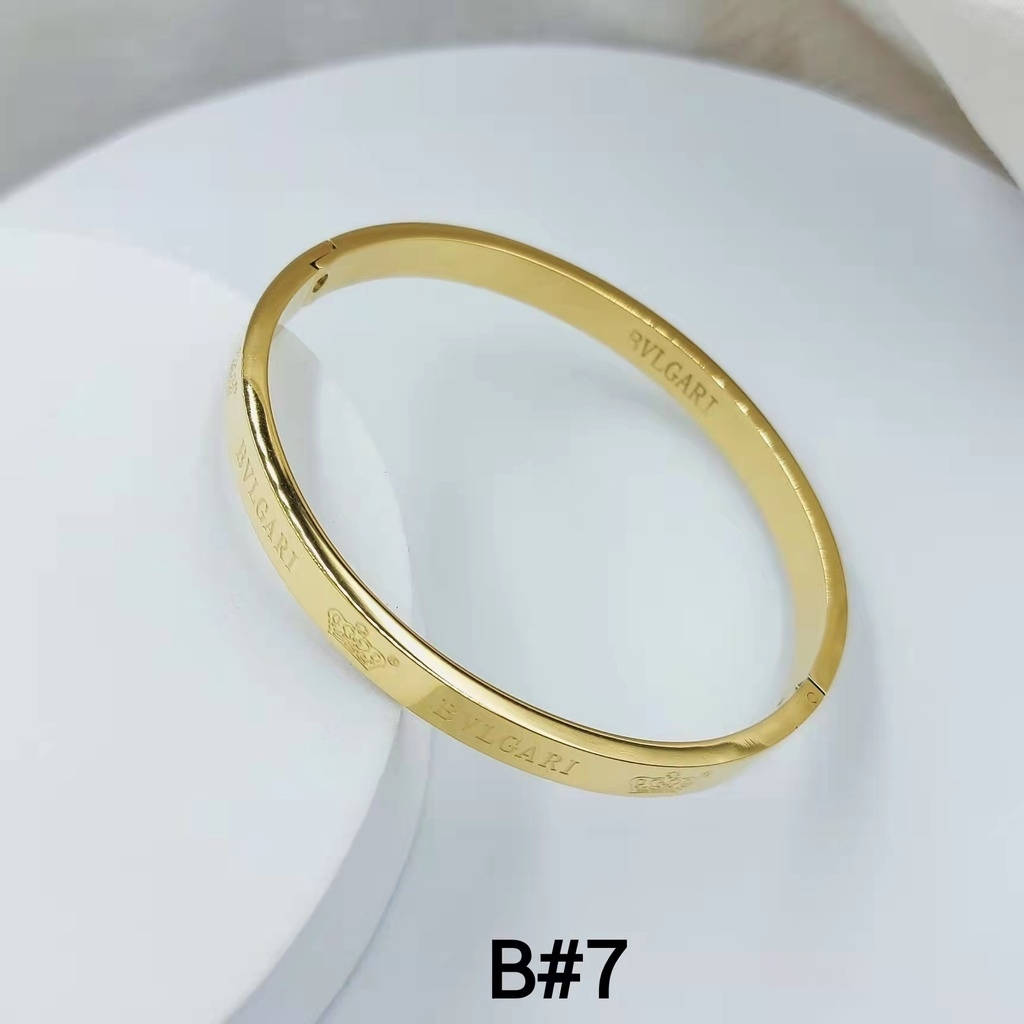 簡約卡地亞細金手鐲 壁紙 — 一隻時尚的黃金Bulgari手鐲優雅地放在白色陶瓷表面上，帶有柔和陰影。