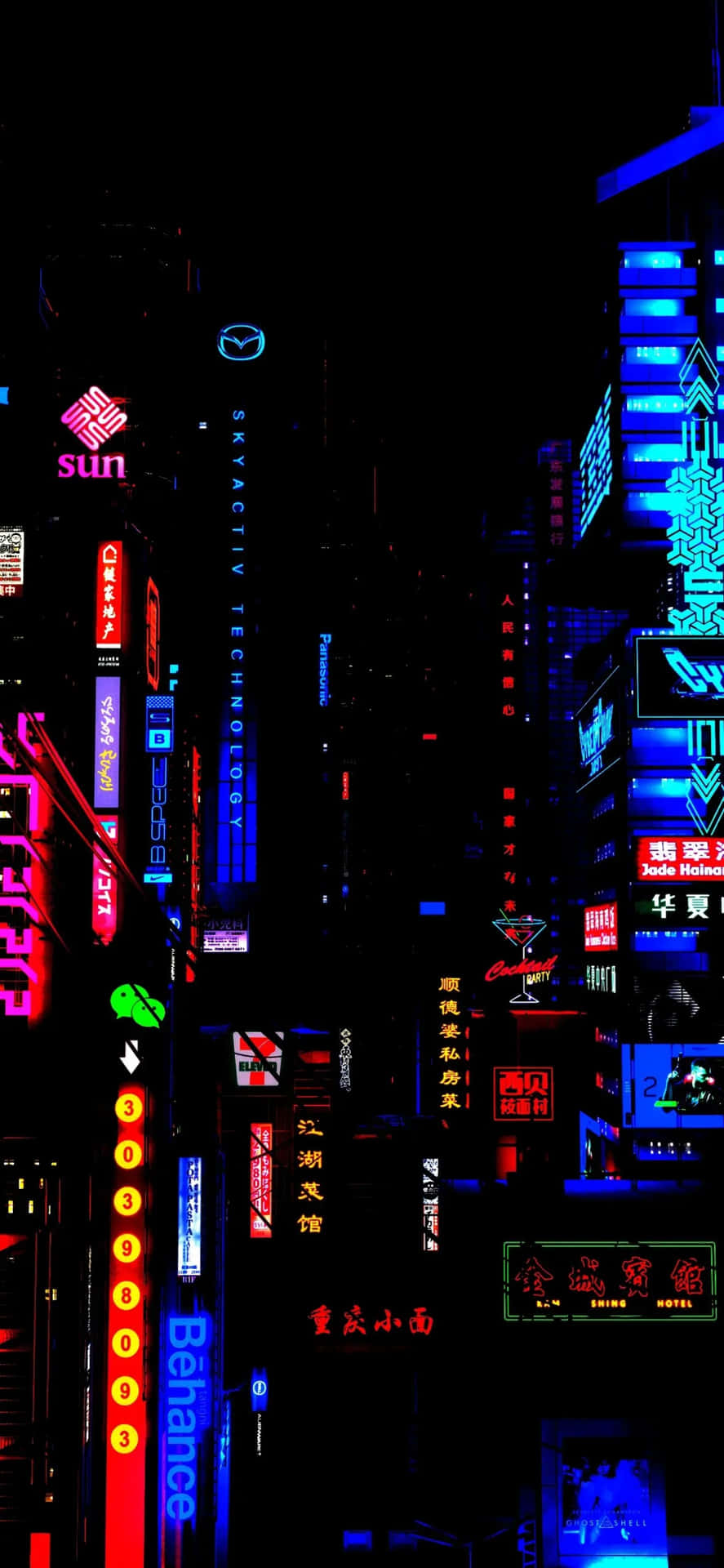  壁紙 — 夜晚高聳的霓虹燈城市景觀，紅色、藍色和綠色的發光招牌映襯著漆黑的天空。