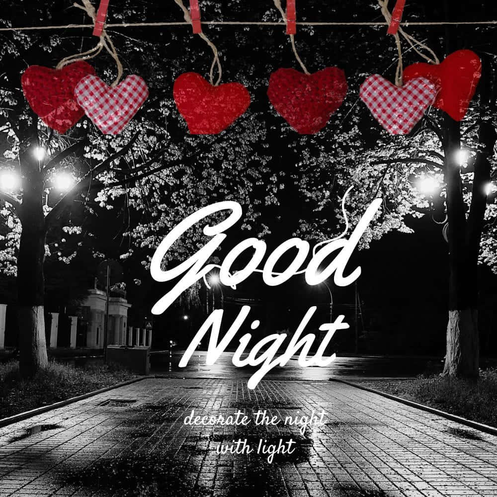  壁紙 — 夜晚街燈下，濕漉漉的鵝卵石小徑上方掛著一串紅色心形，並帶有「晚安」文字。