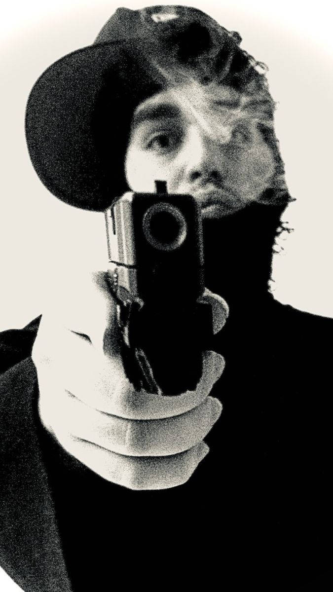 Yeat 手持手槍 壁紙 — 戴帽的人手持手槍指向鏡頭，煙霧在臉部周圍旋轉，呈現鮮明的黑白照片。