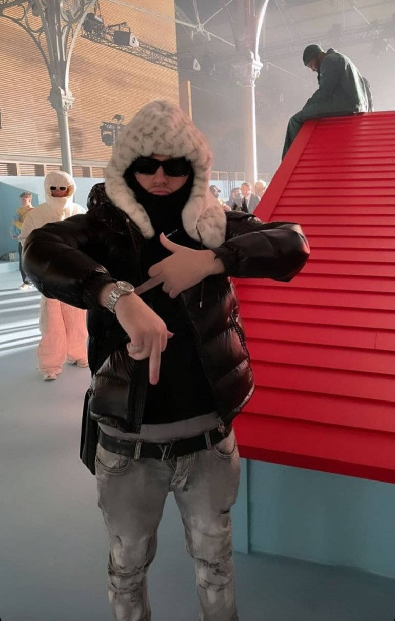 穿羽絨外套男子指著手錶靠近紅色樓梯