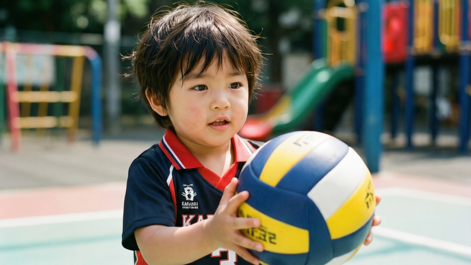kei tsukishima 桌布 壁紙 — 一個穿著運動球衣的小孩在色彩繽紛的遊樂場上，在明亮的陽光下拿著排球。